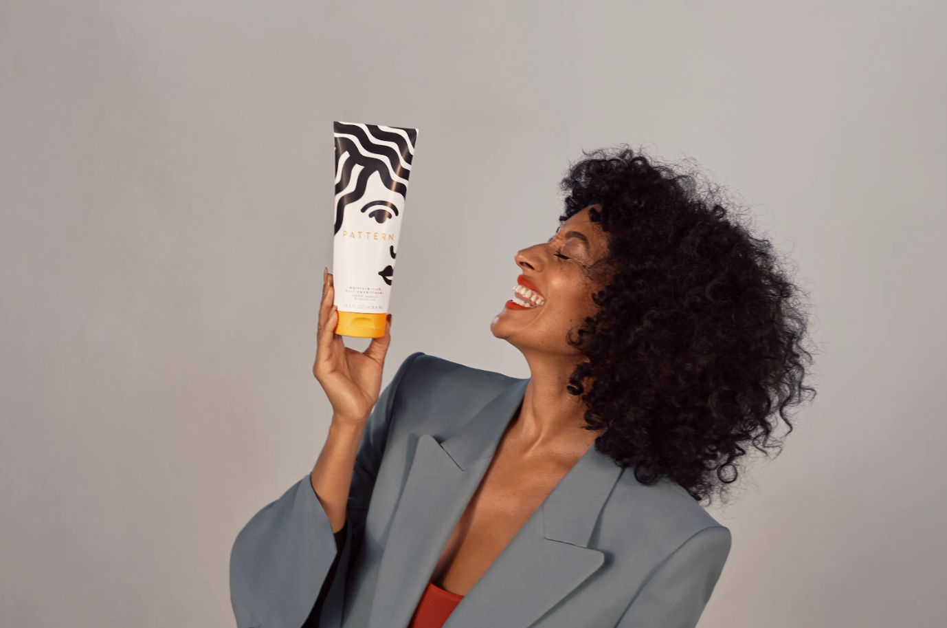 Woman standing with skincare product bottle