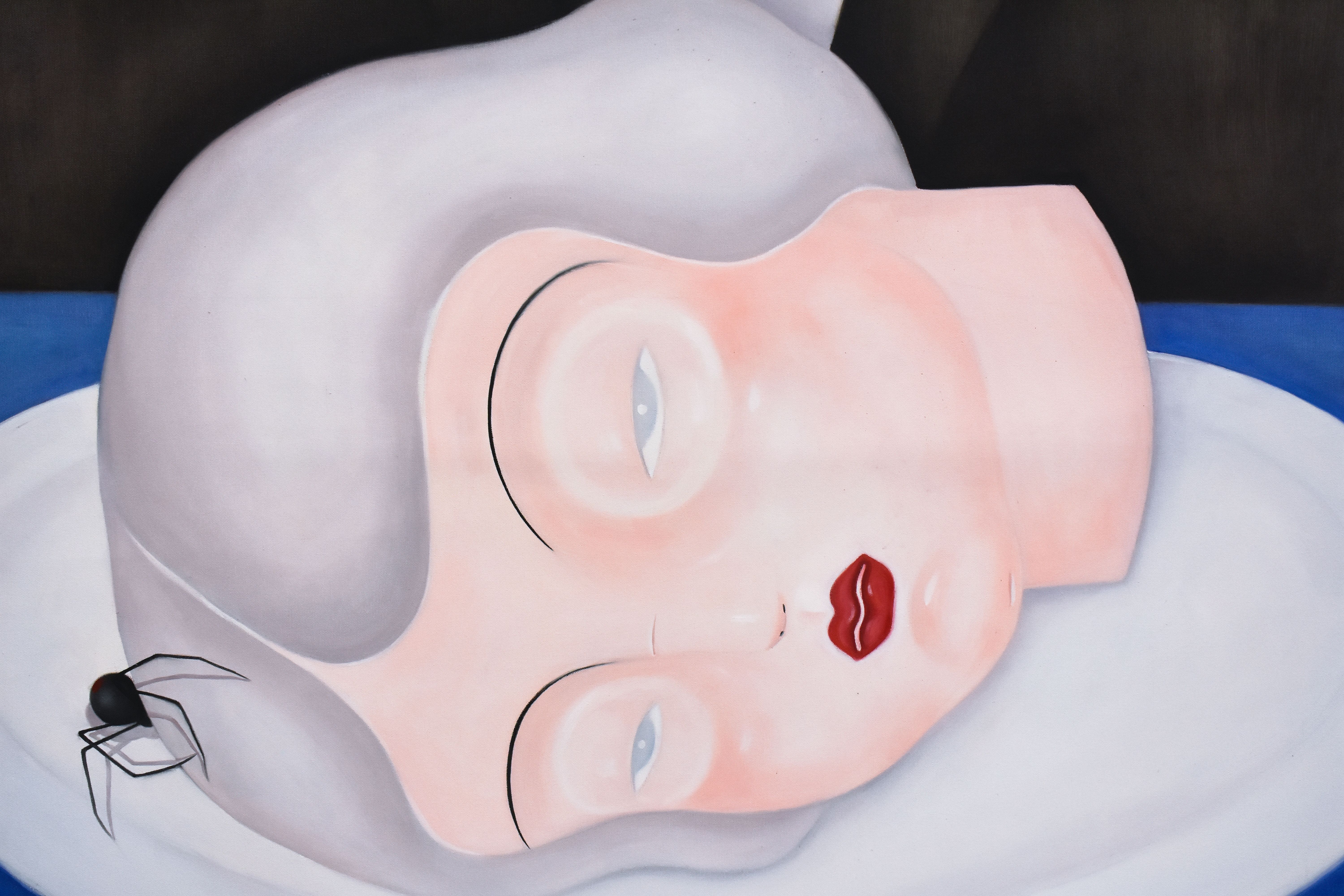 A painting of a severed girl's head on a plate, she has red lipstick and grey hair. There is a spider on the top of her head