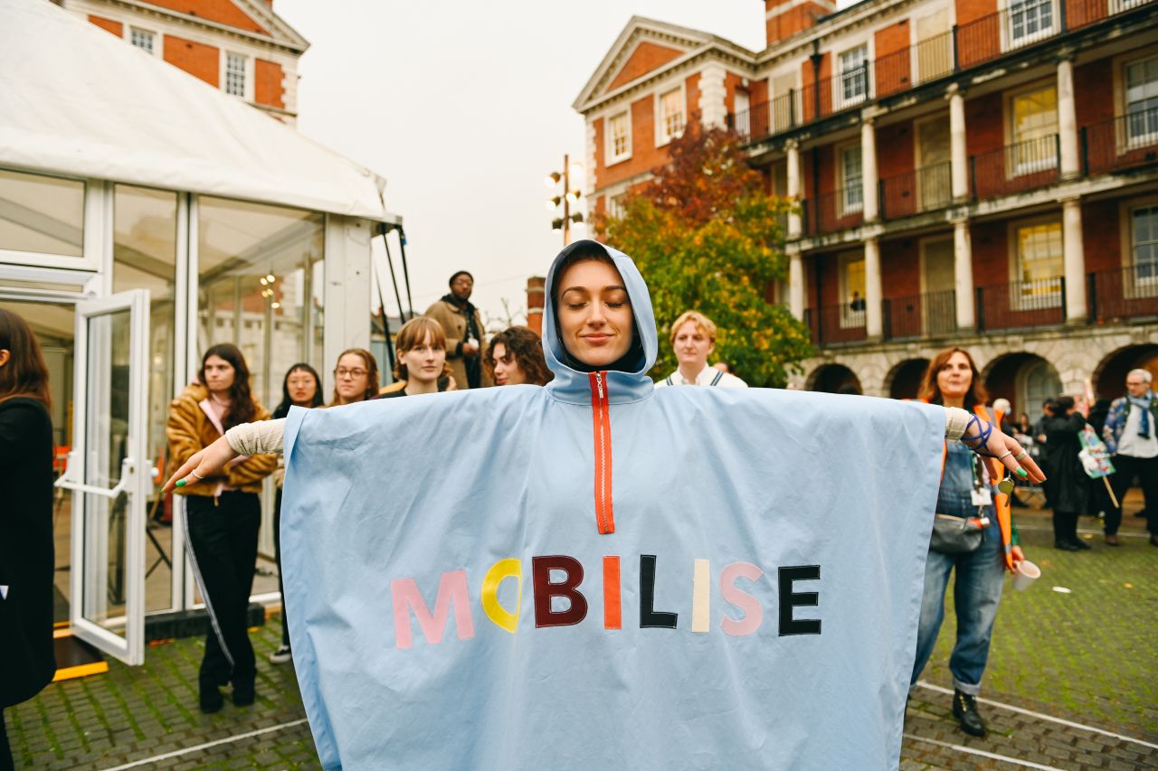 A person wearing a poncho that says mobilise