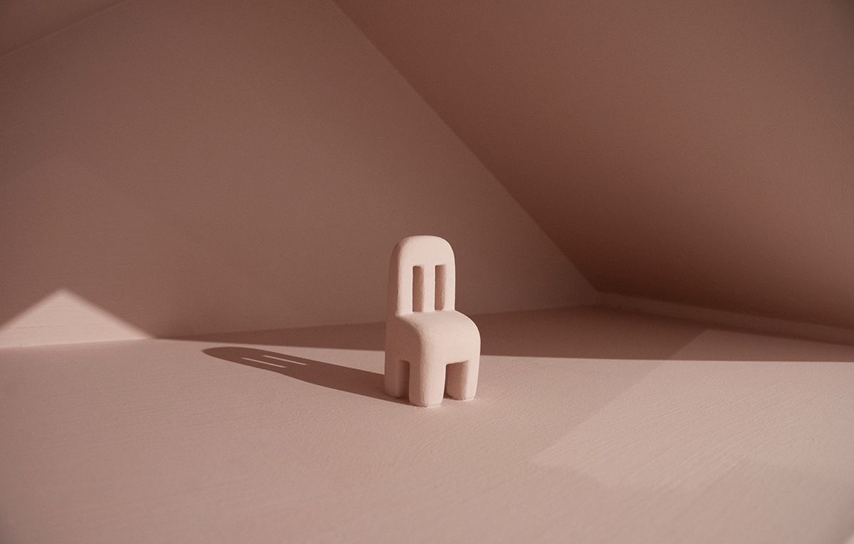 A small sculpture of a pink chair.