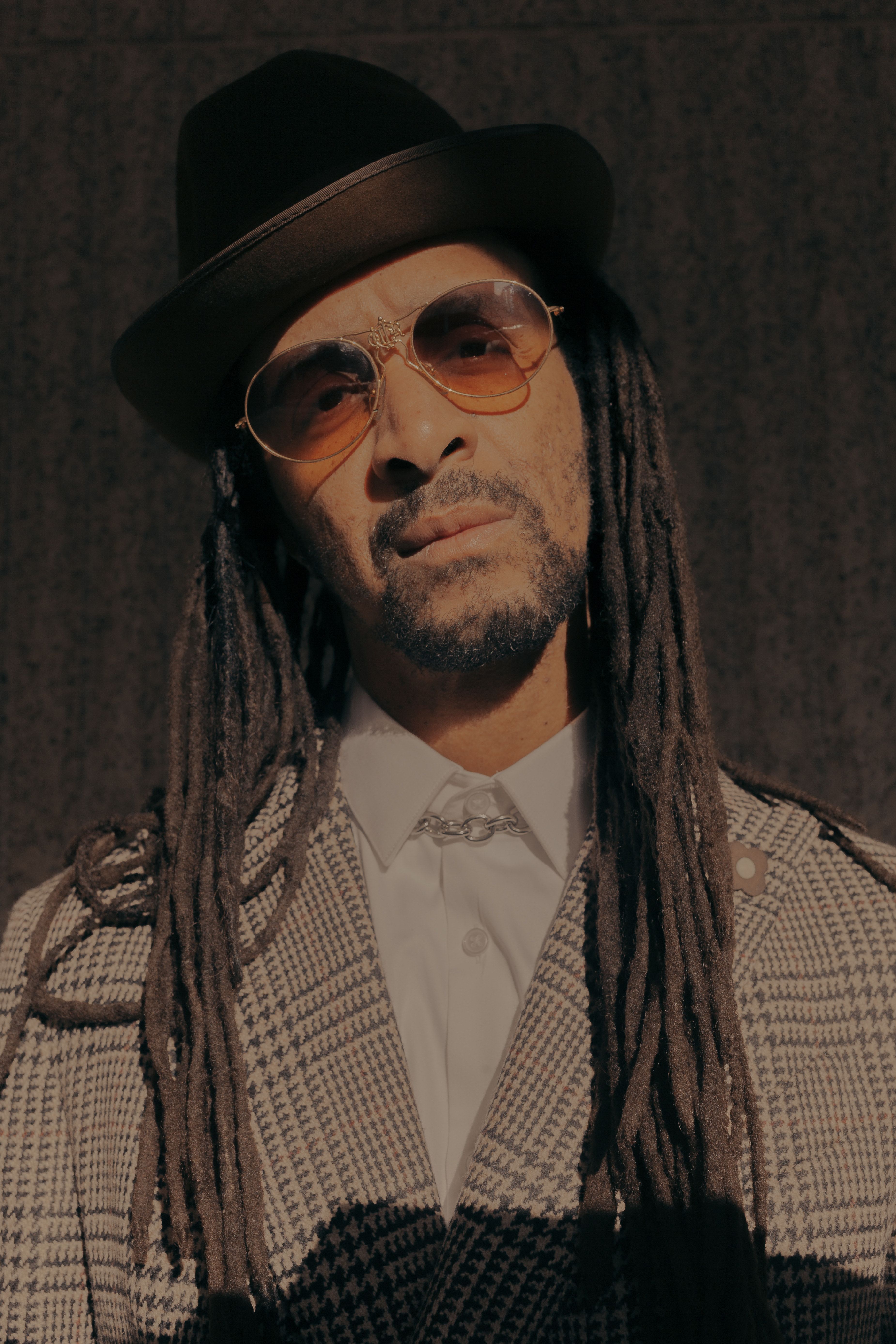 Headshot of Harris Elliott wearing sunglasses, a hat and tweed jacket.