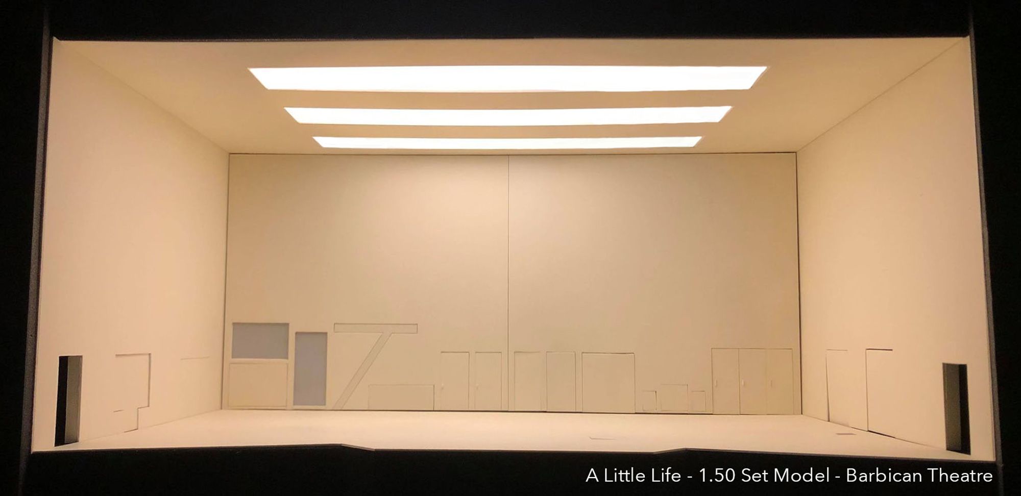 A set model of a cream coloured room lit from above