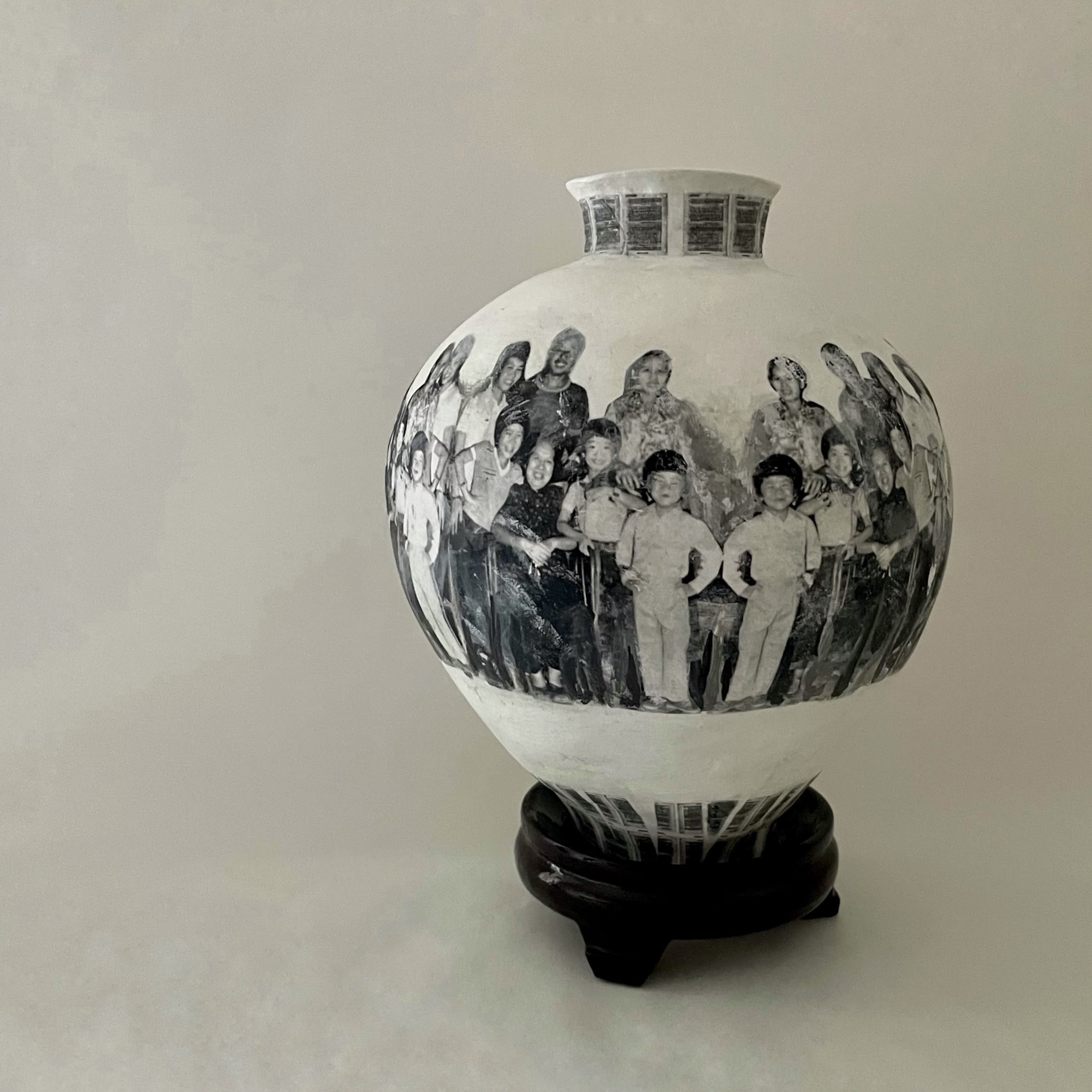 A clay pot with portraits of a family printed onto it