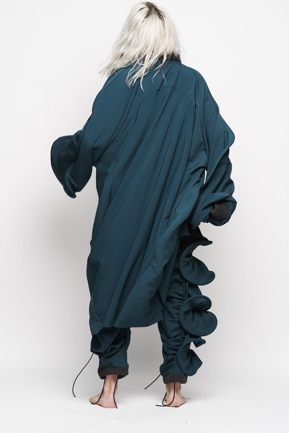 Woman with blonde hair facing away from camera in blue dress