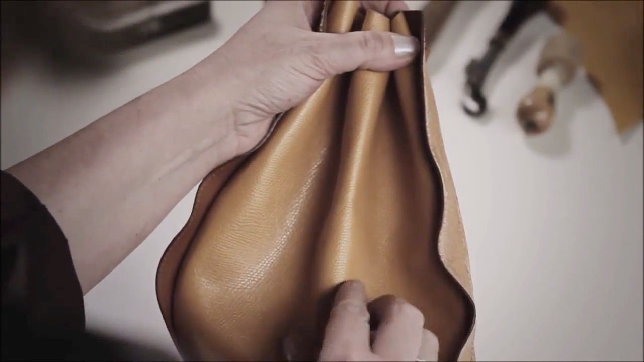 Woman's hands crafting leather goods