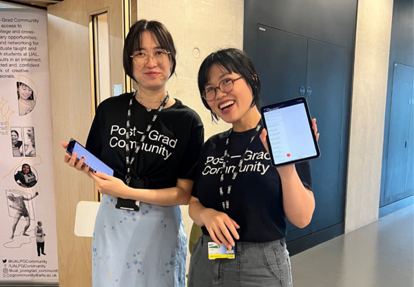 Two students standing side by side and looking at the camera