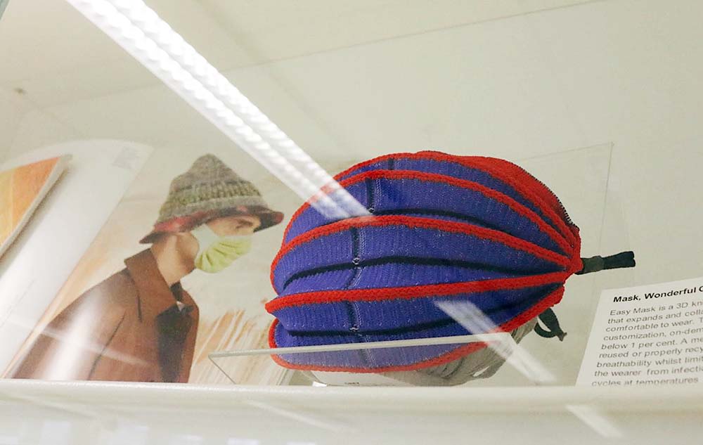Knitted face mask in a glass case.