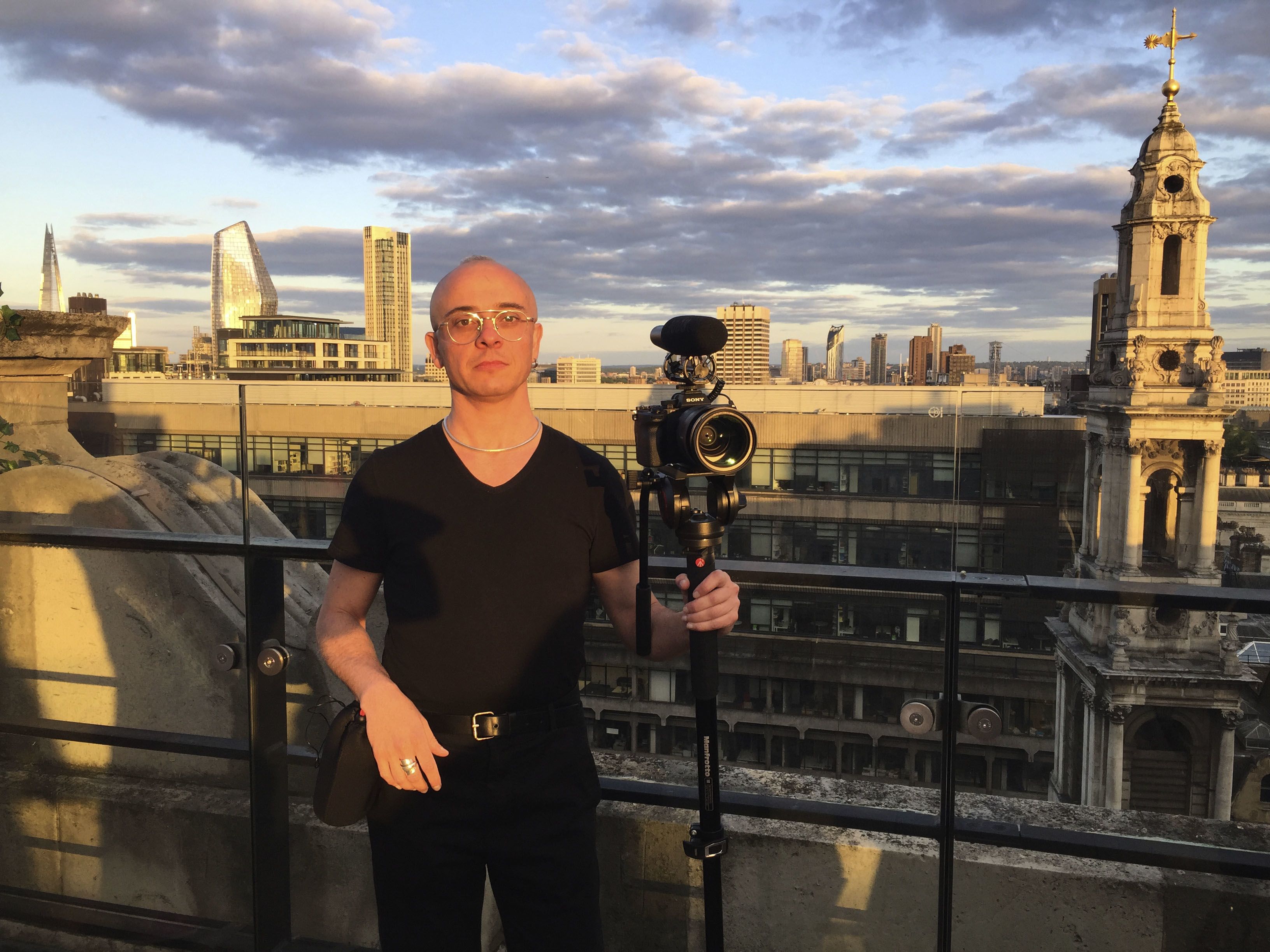 Portrait of Orlando holding his camera on a London rooftop