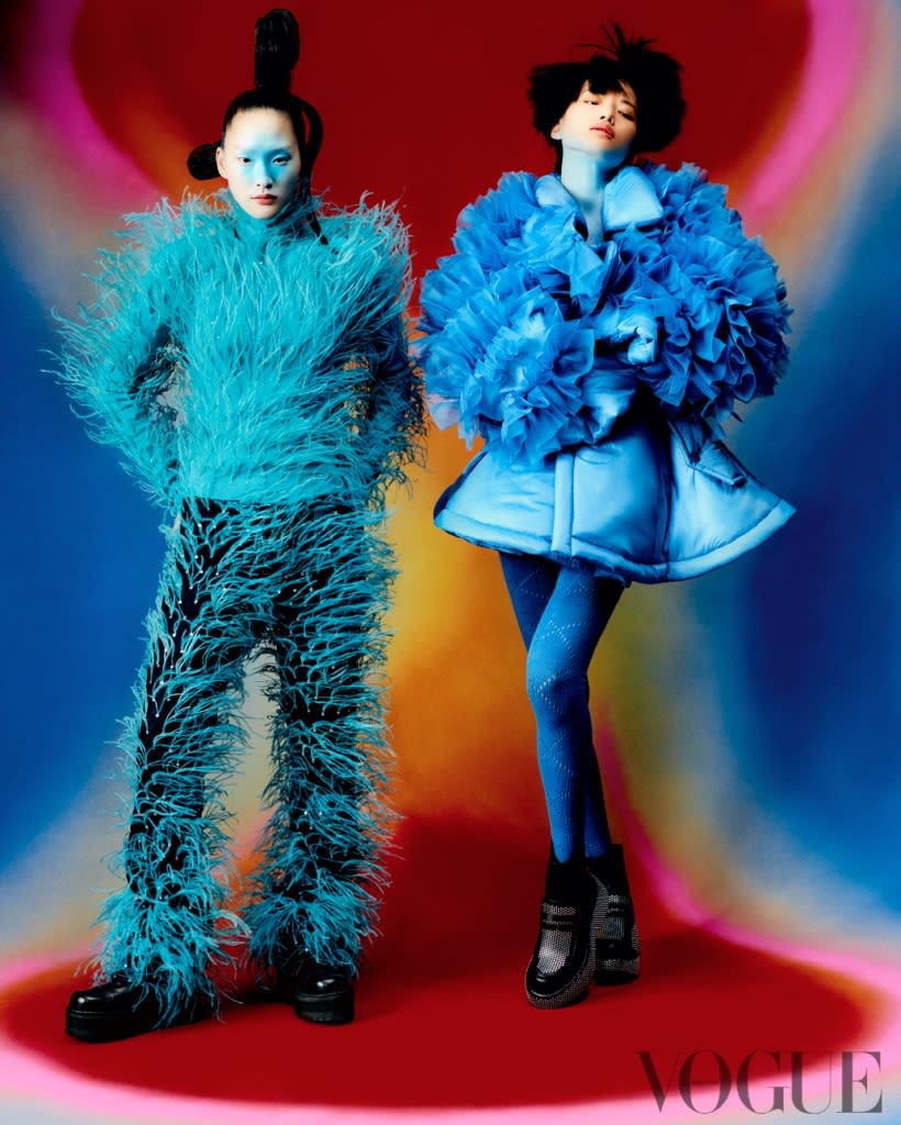Photoshoot by Holmes Production. Two models in blue outfits, against a tie-die background