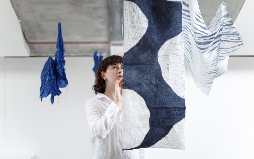 Textile work on display, with a visitor interacting with the installation