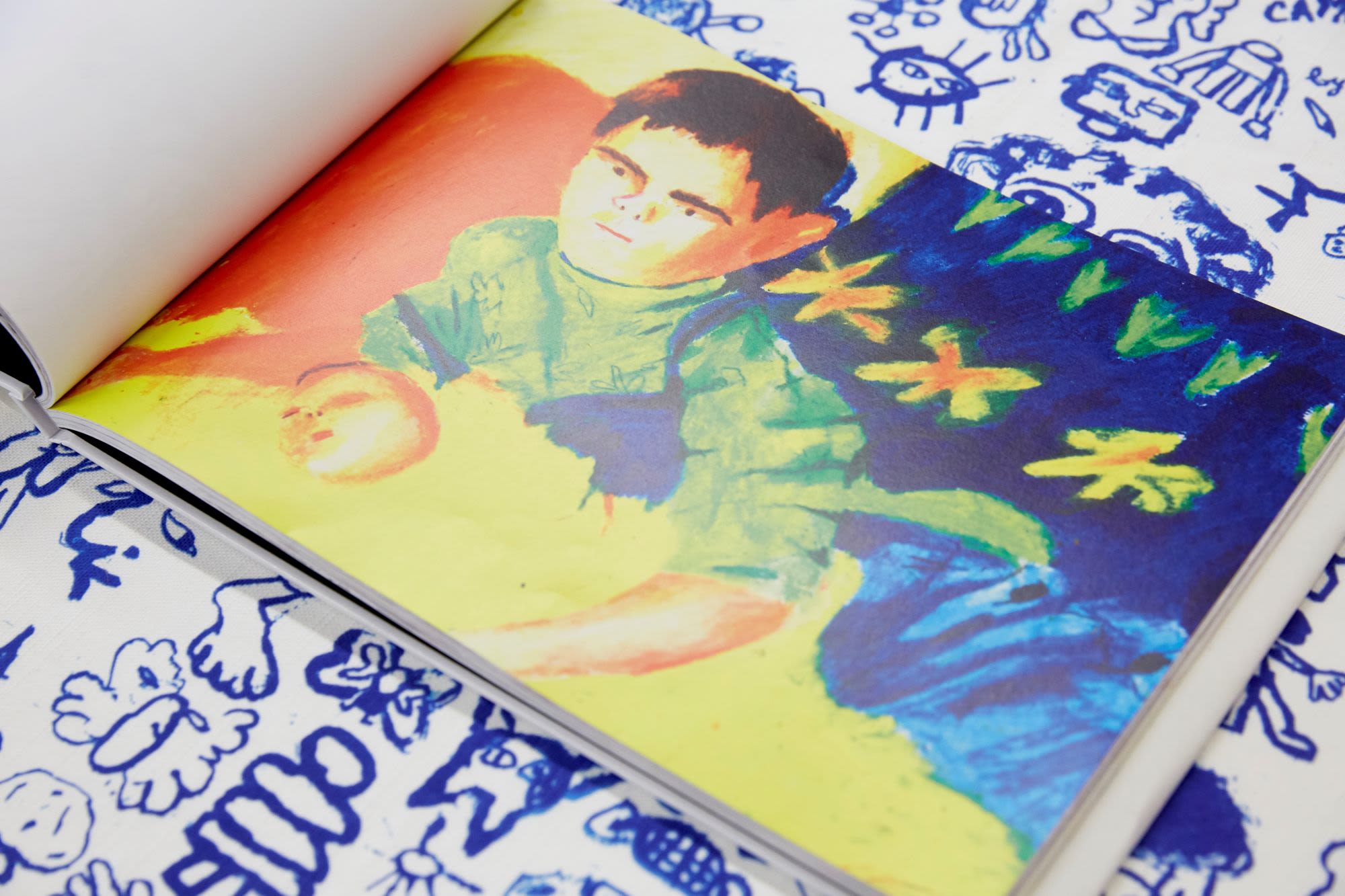 Drawing of a young boy with brown hair wearing a green top covered in flowers. Below him there is a drawing of a floating head.