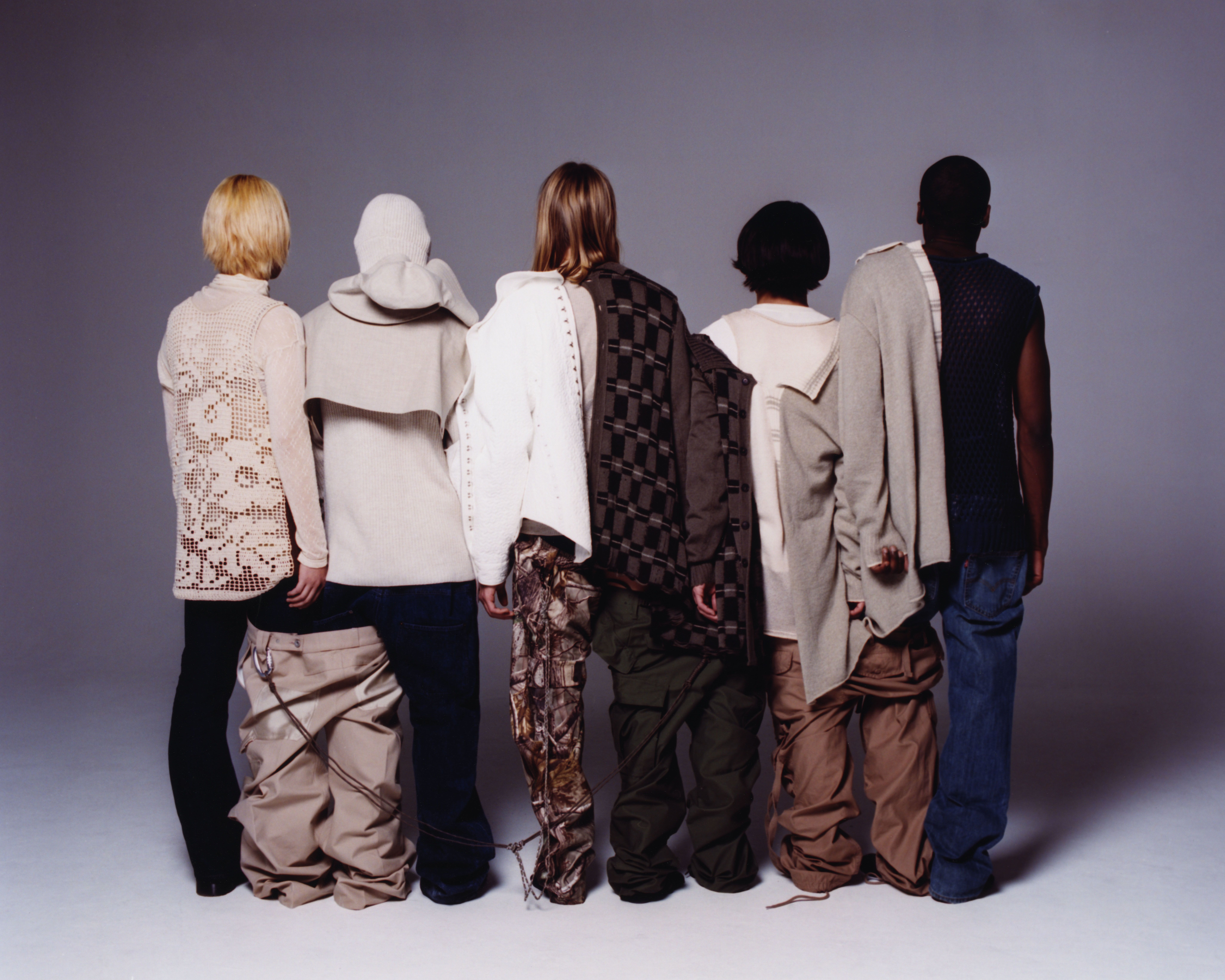5 models with their backs to the scene, in front of white background