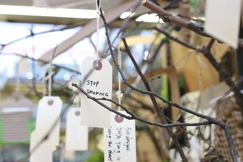 Tree branches with hanging handwritten tags with people's notes written on them