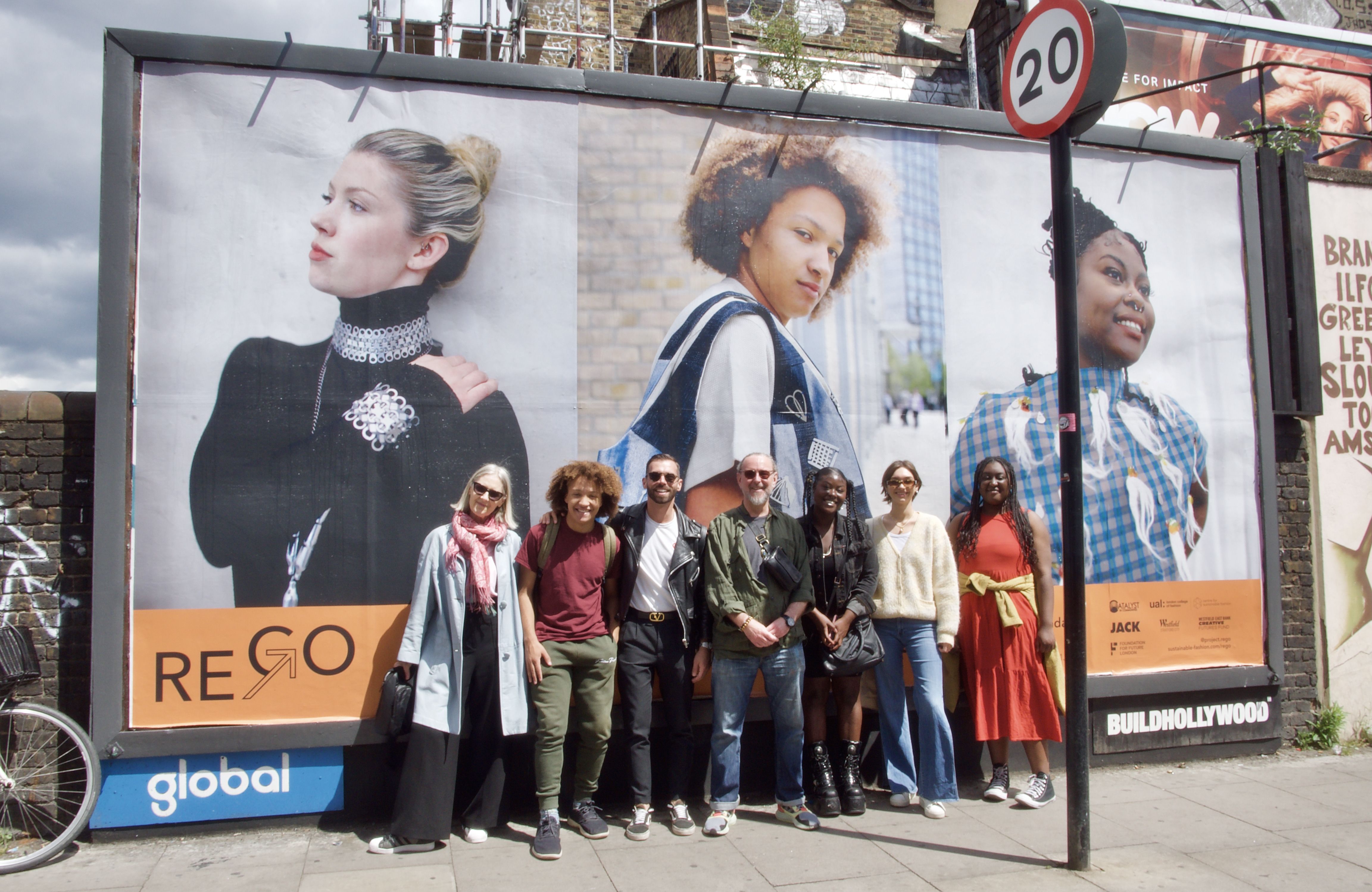 A group of people posing in front of a street billboard
