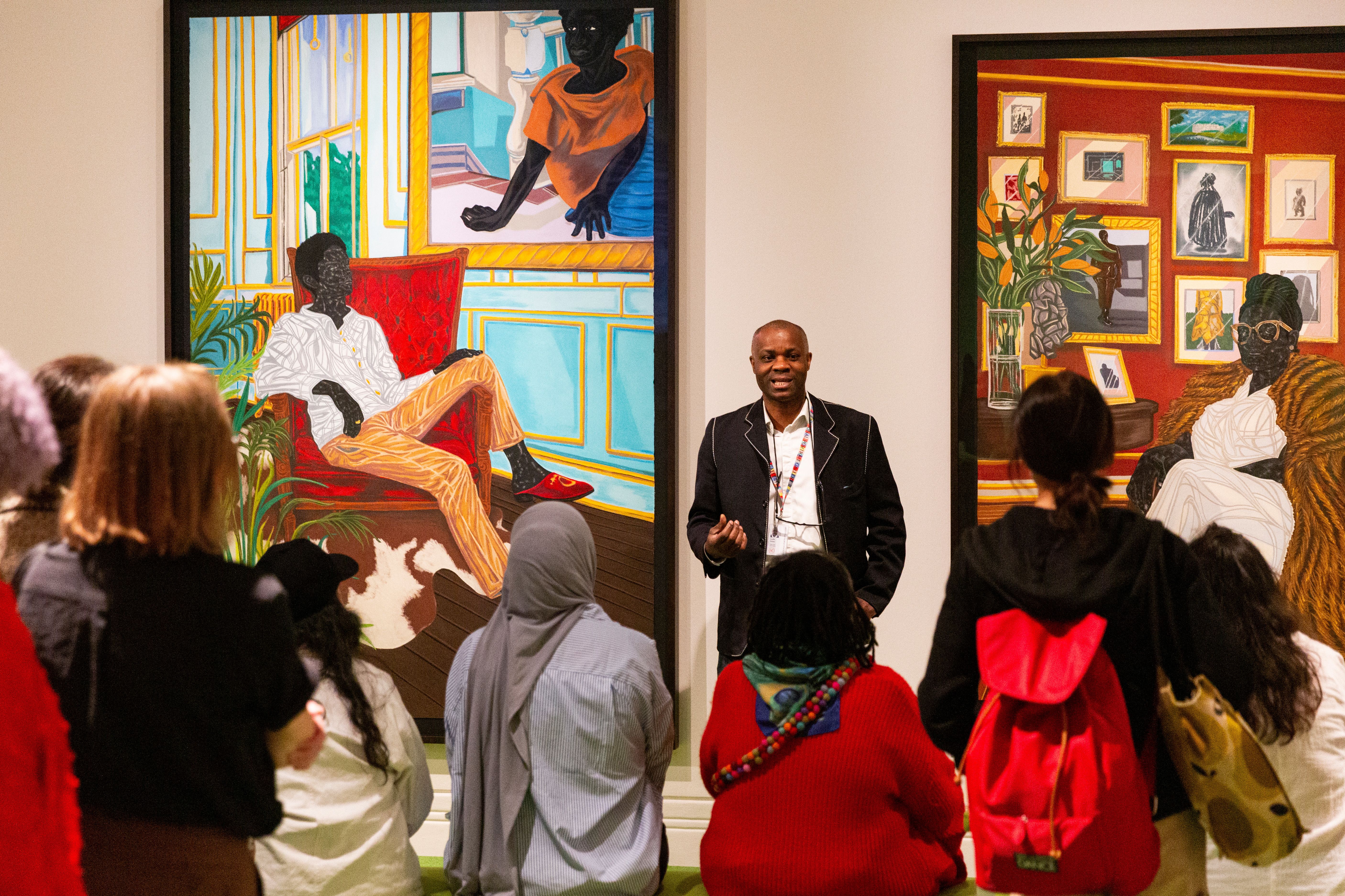 Leslie stood in front of the group. On either side are paintings