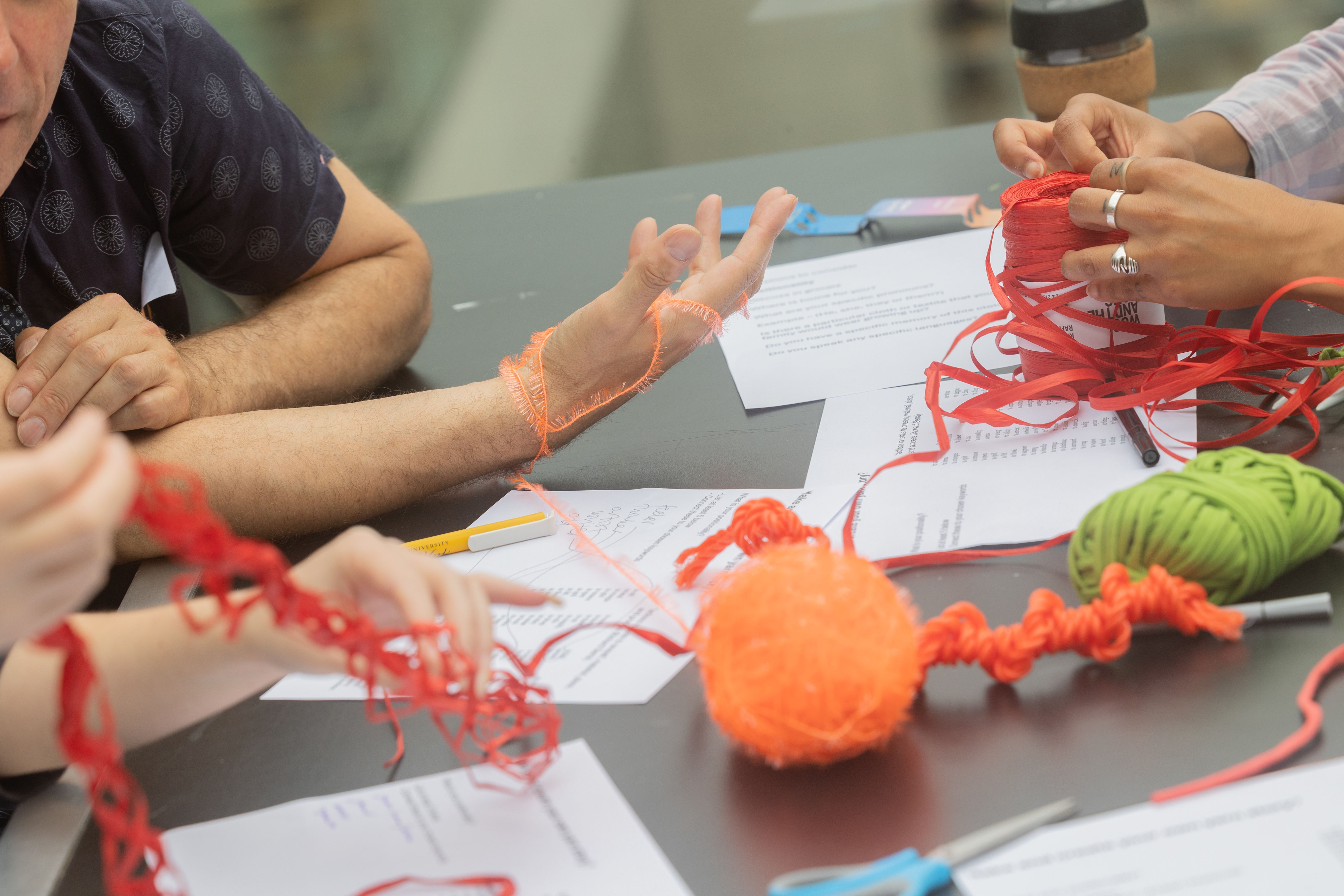 Hands playing with colourful string set on a table