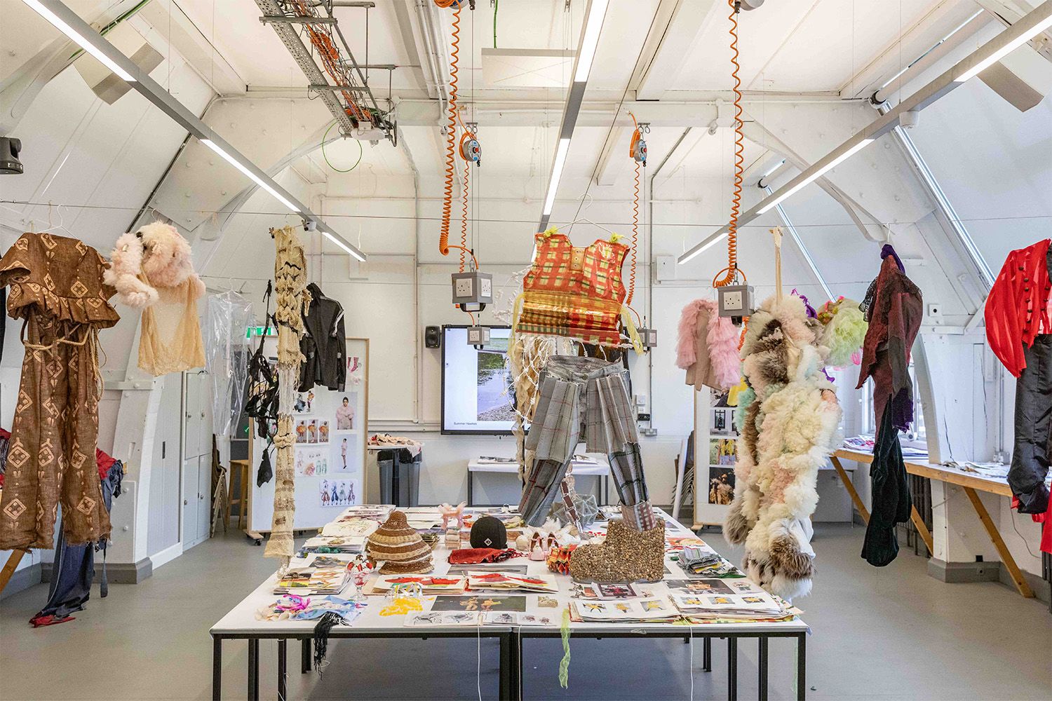 Desks, mannequins and fashion items in a classroom environment