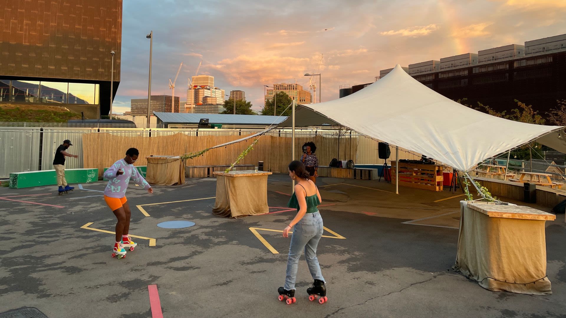 People roller skating on a rooftop on a summer's evening