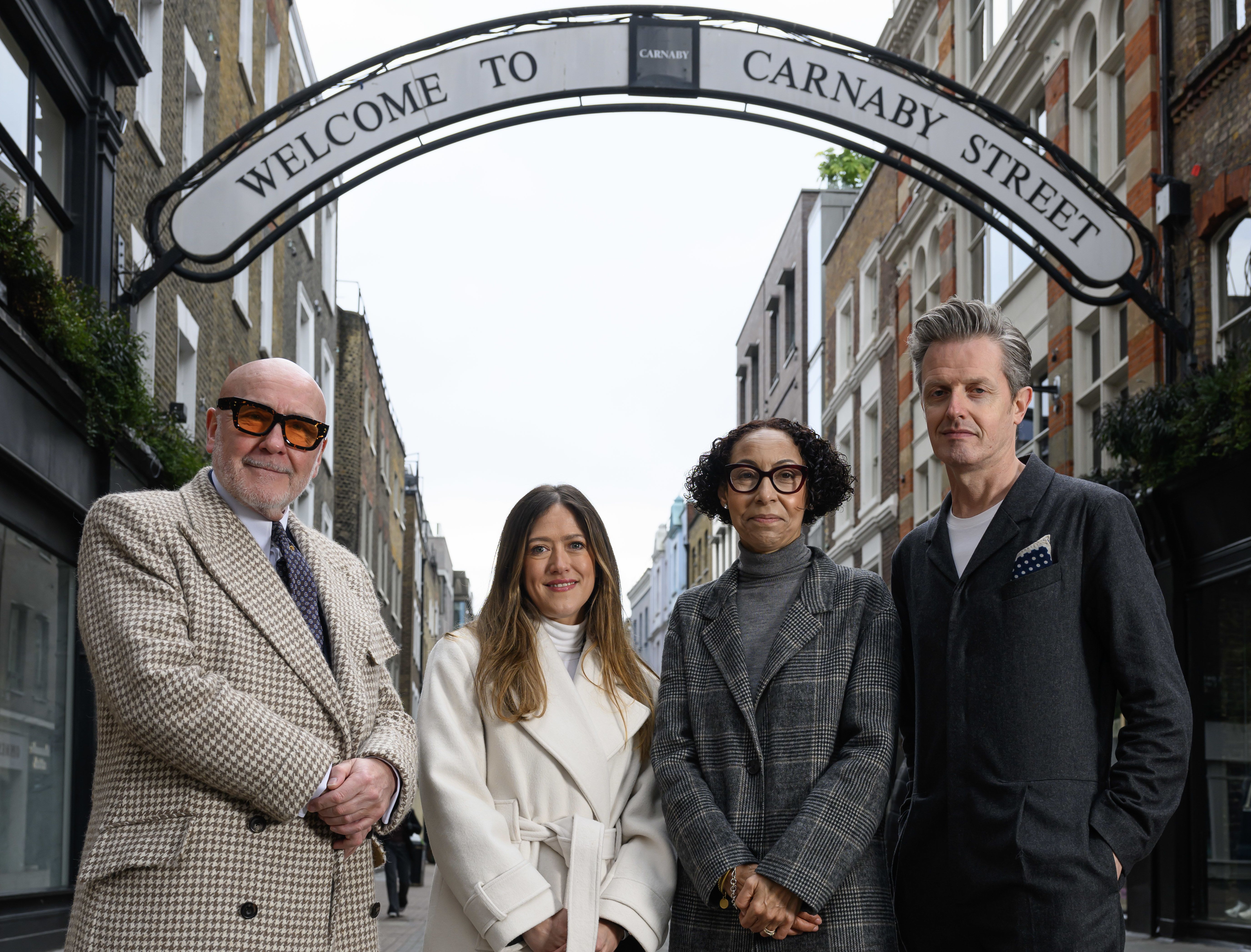 Four people stand under the 