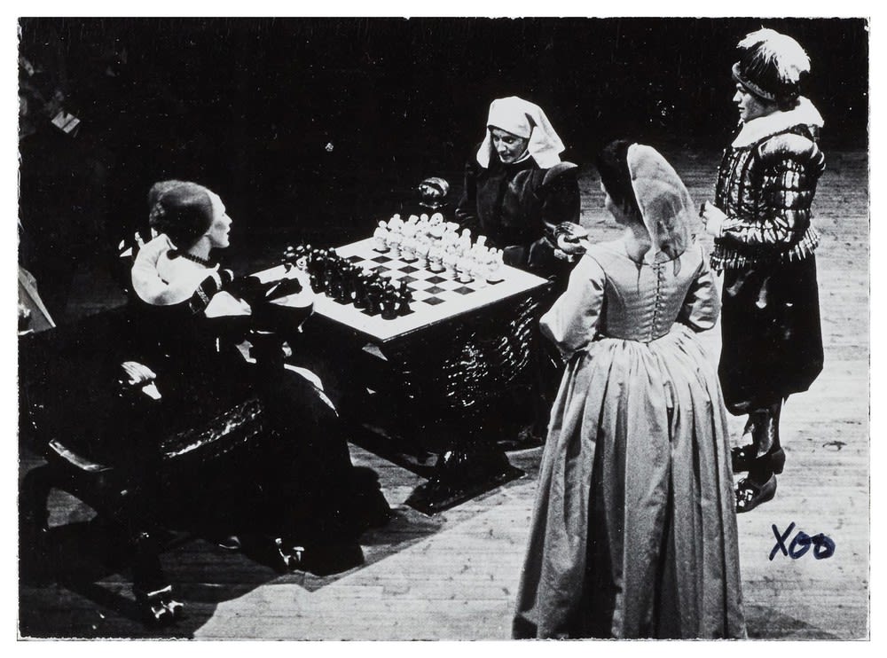 Black and white image of four women around a chess board