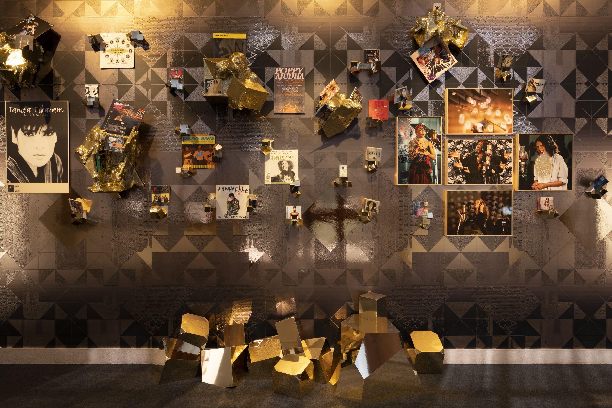 A photograph of a wall with various music memorabilia on it. 