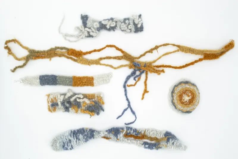 Six different knitted shapes ranging from long to circular, in colours from oranges to blues. 
