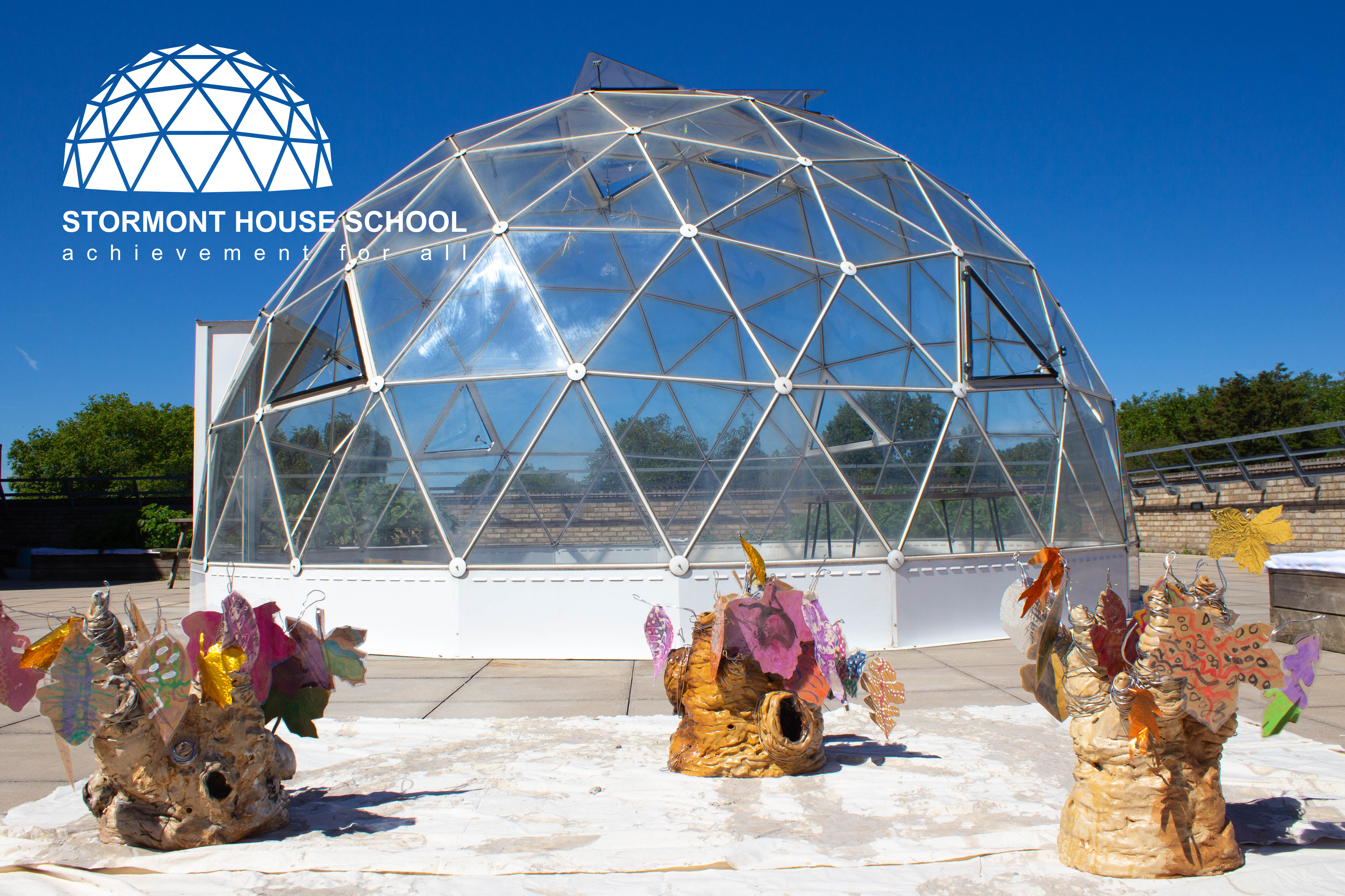 A photo of a glass dome with floral sculptures surrounding it