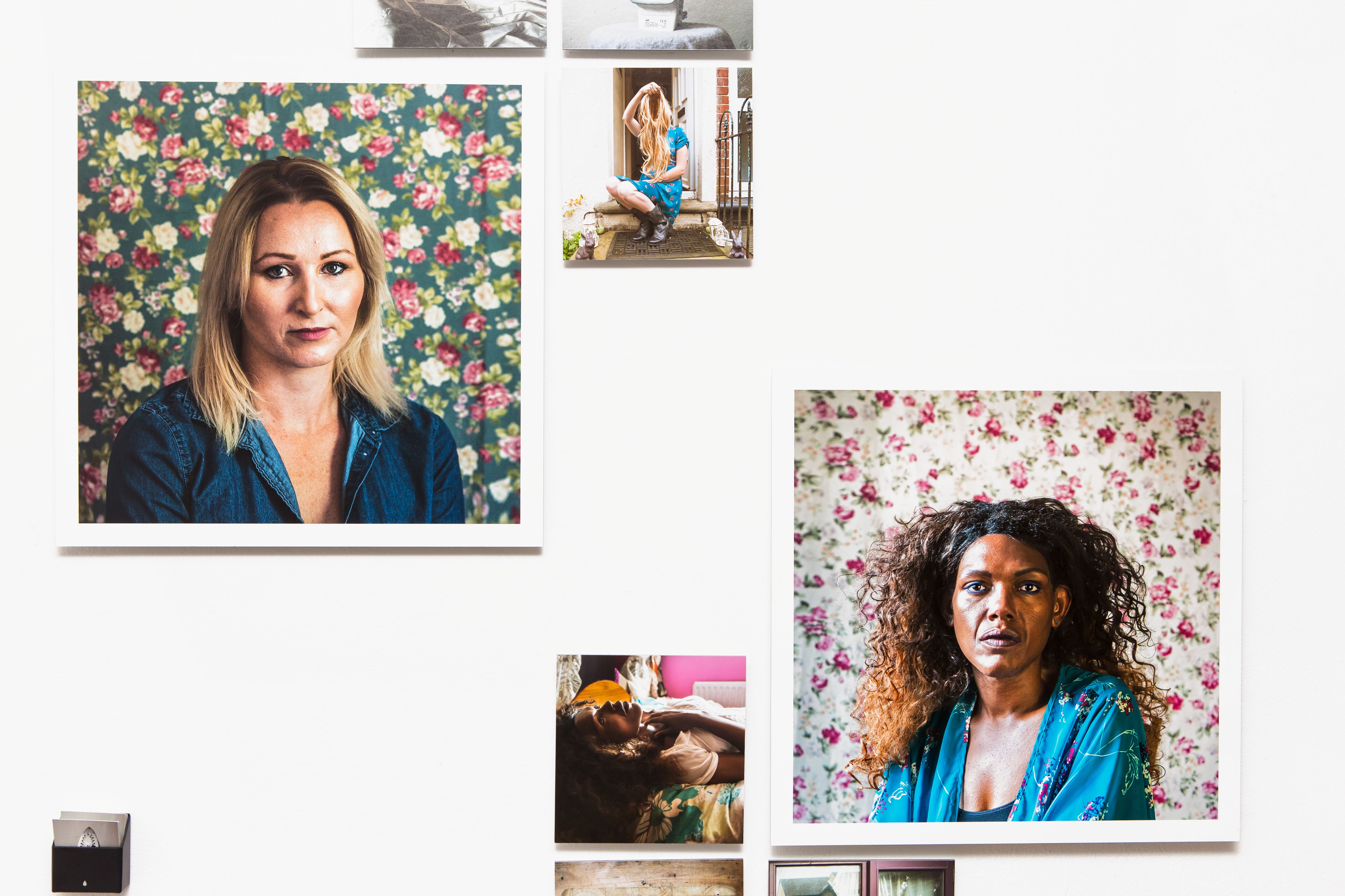 A gallery wall of various portraits of women.
