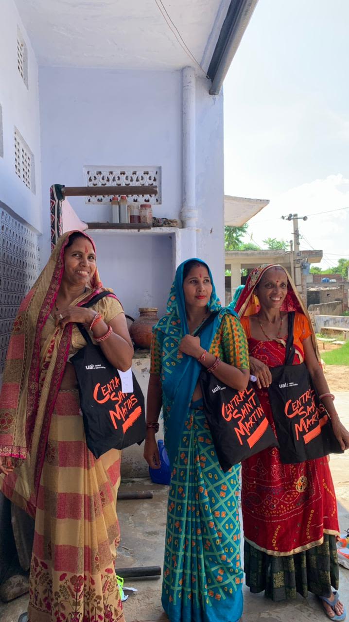 three people posing with branded tote bags