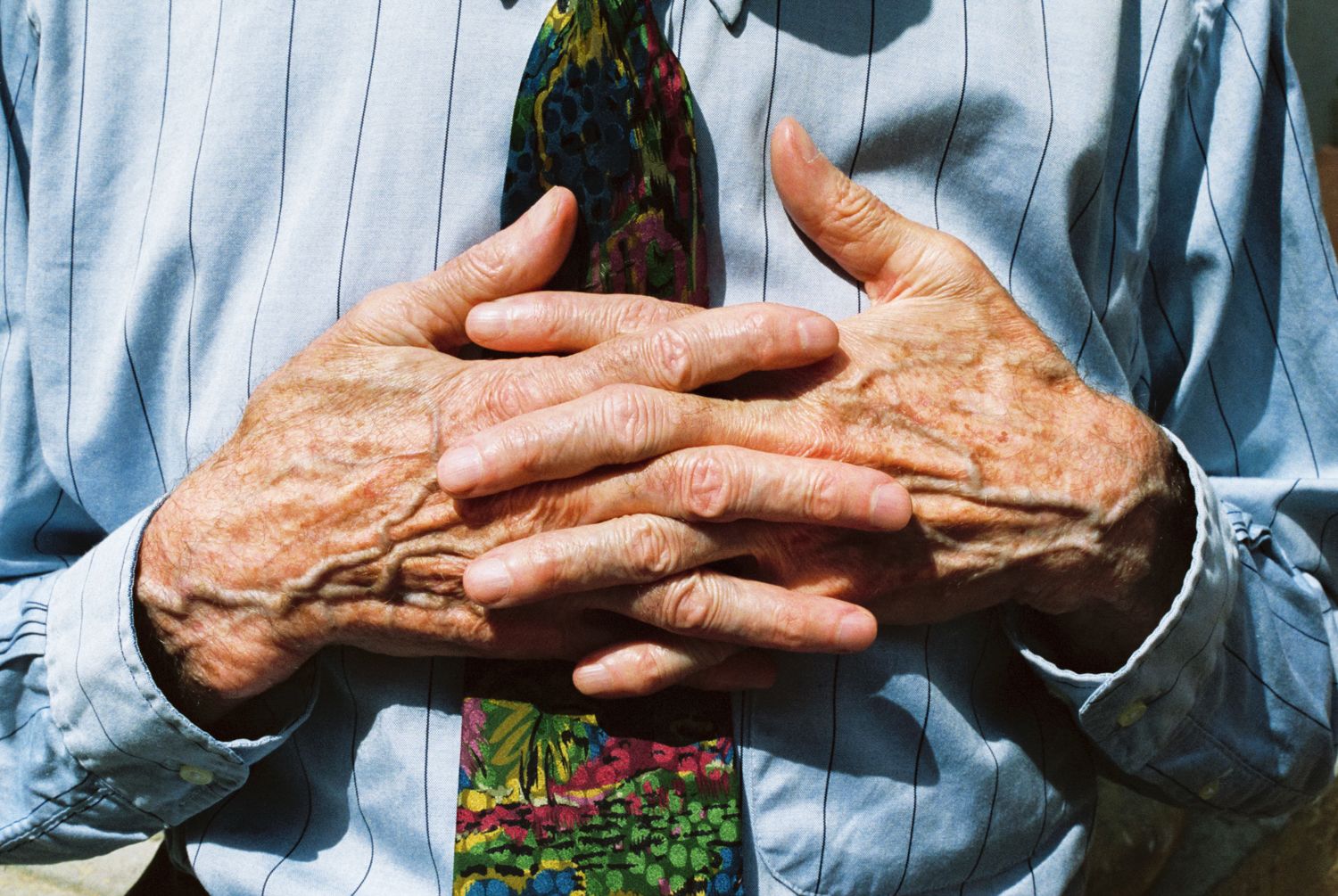 elderly gentleman hands intwined together