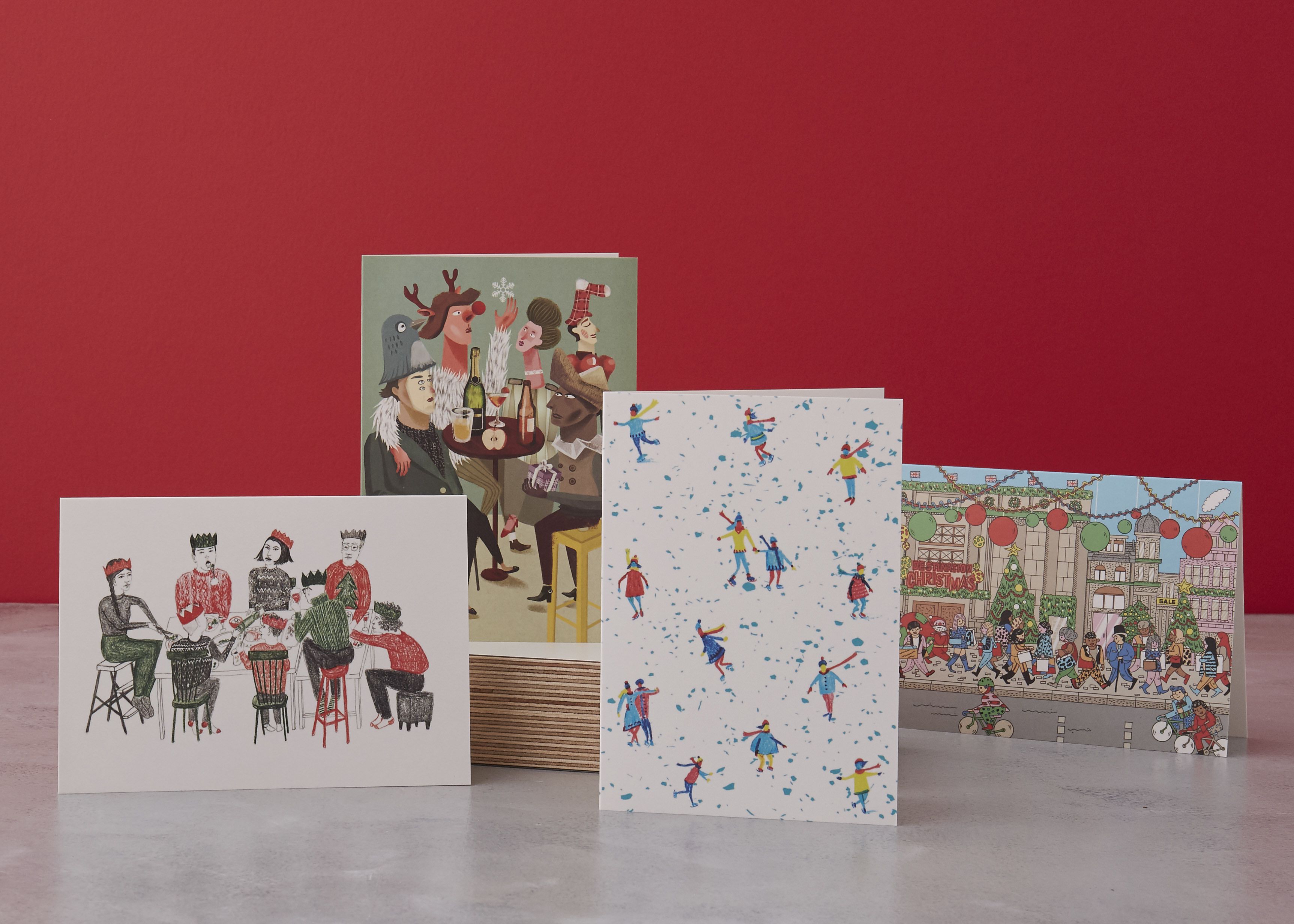 A selection of Christmas cards set against a red background