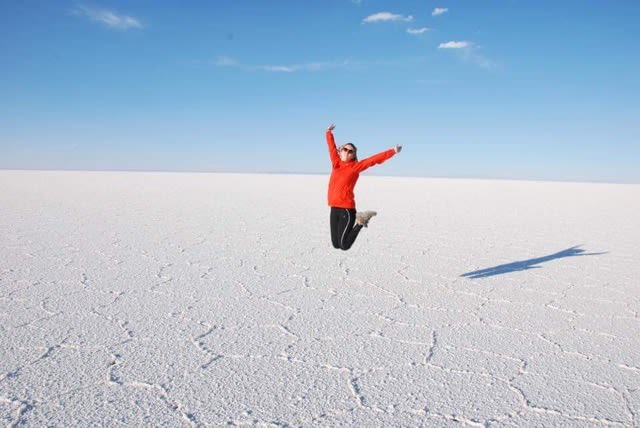 An-Sophie leaping in the air in joy, photographed on ice in what looks like a glacer