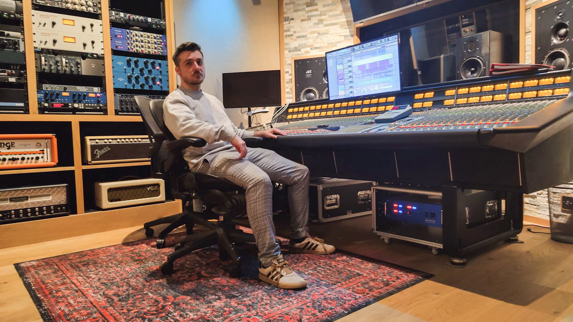 luigino sitting at a mixing console in his studio