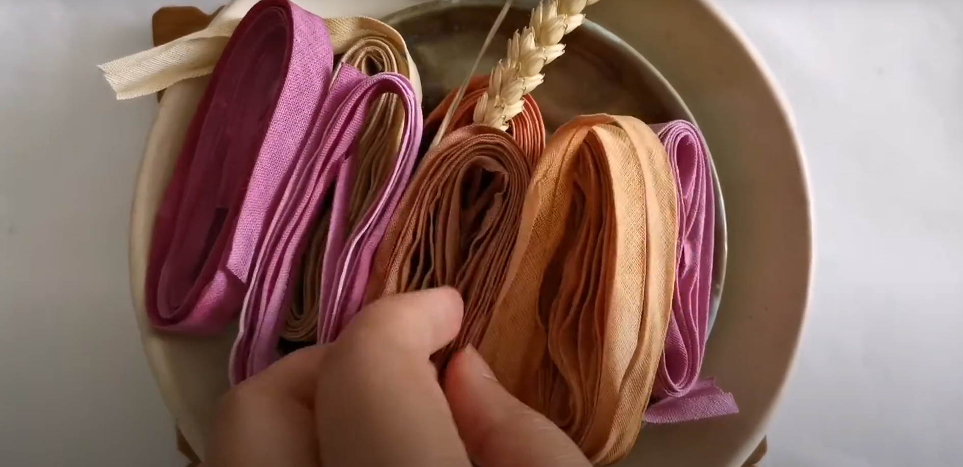 A bowl of earthy and pink cotton ribbons 