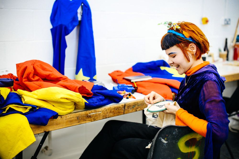 A student embroidering fabric.