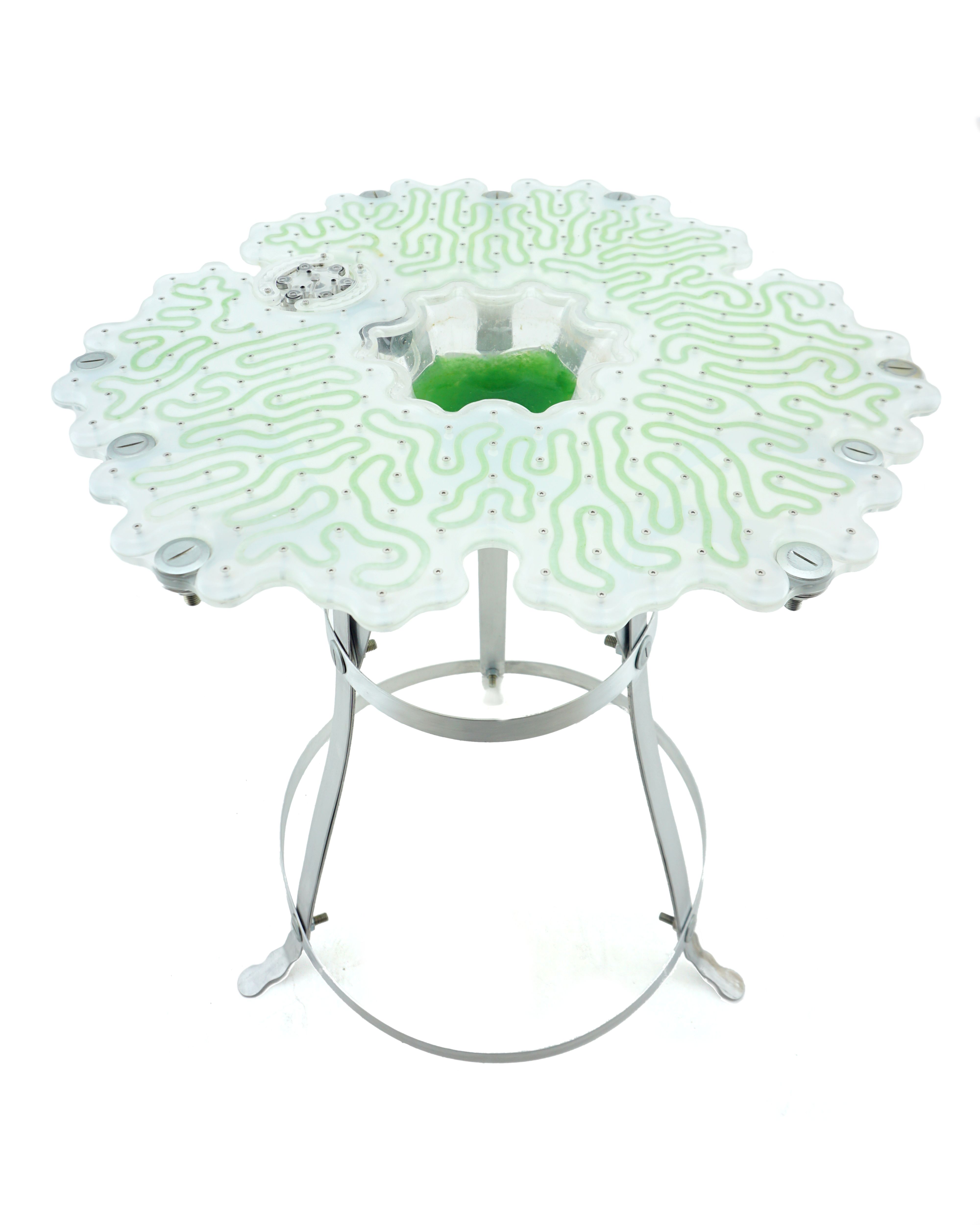 A table with green circuit board made of algae and metal legs