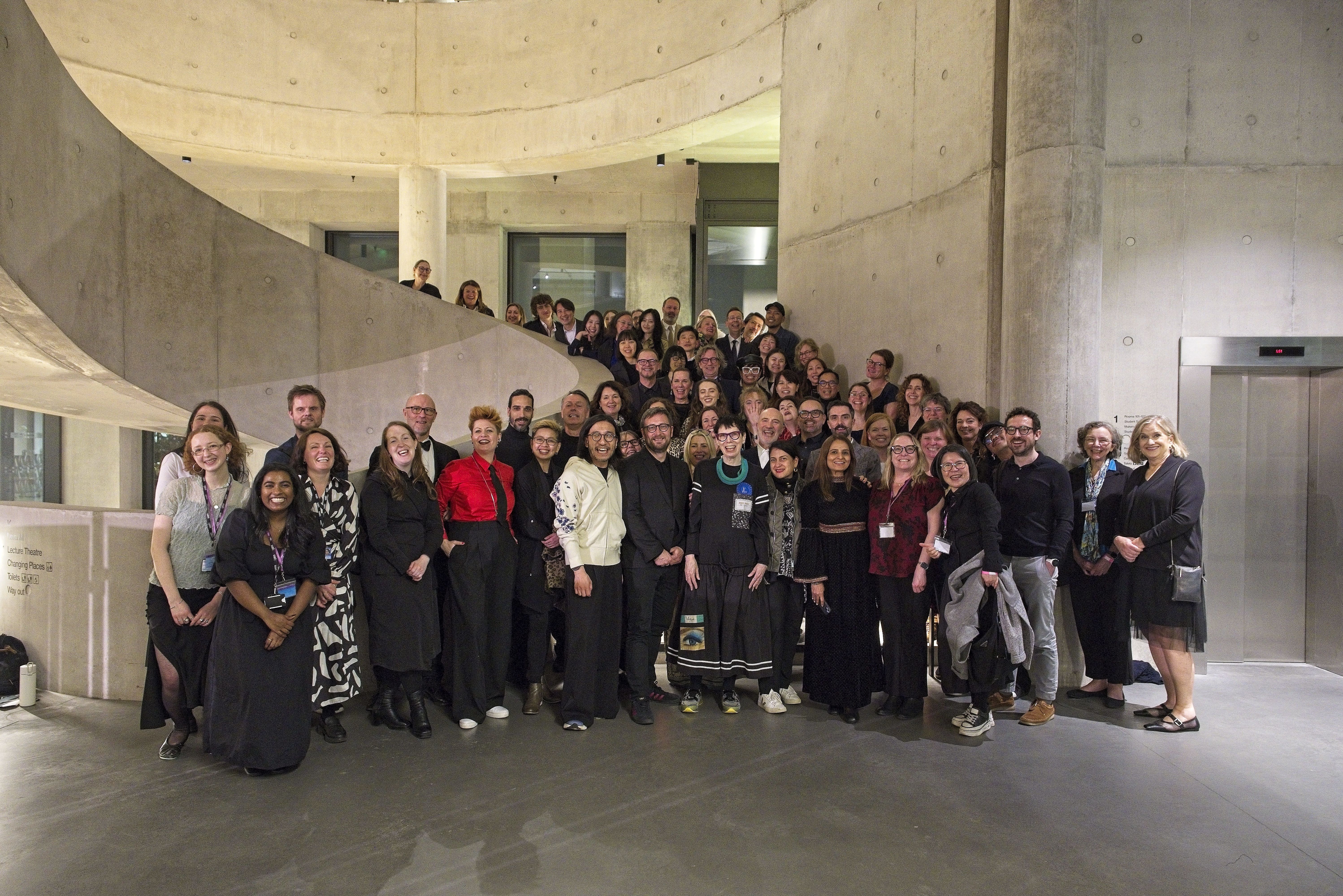 Group of people posing on a concrete stair case.