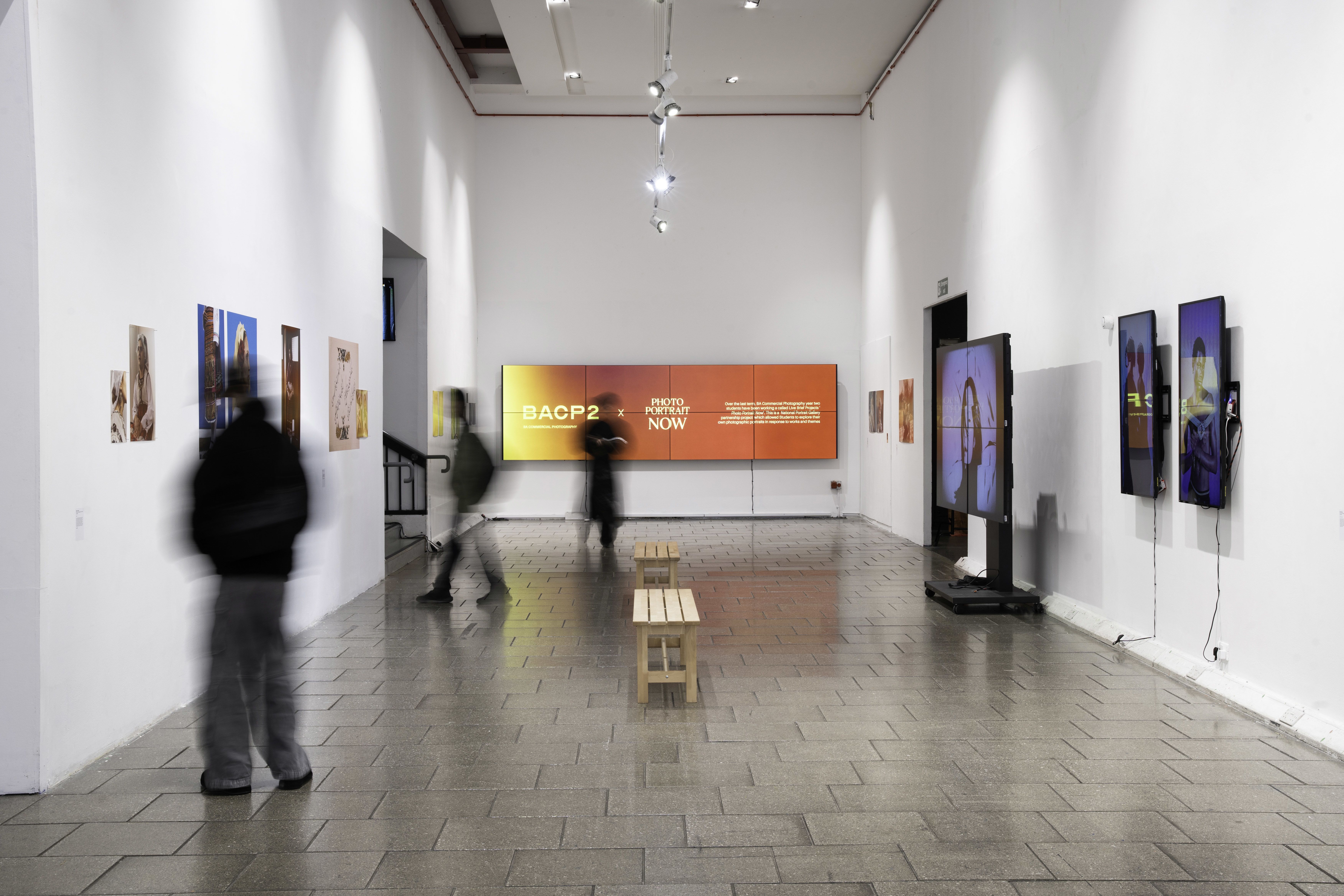 Students walk through the BA (Hons) Photography and Creative Industries exhibition presented in partnership with the National Portrait Gallery.