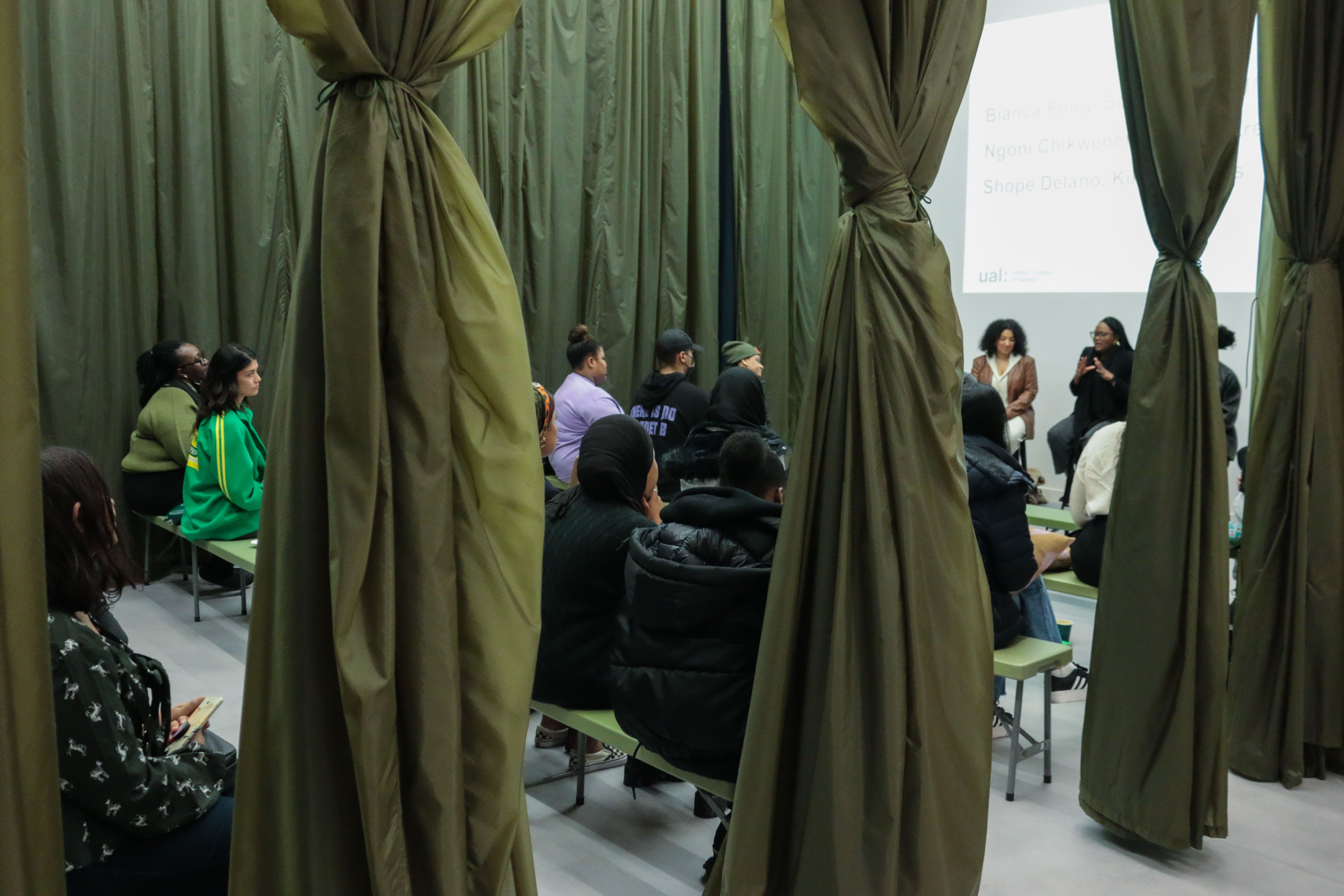 view of listening audience through green curtains
