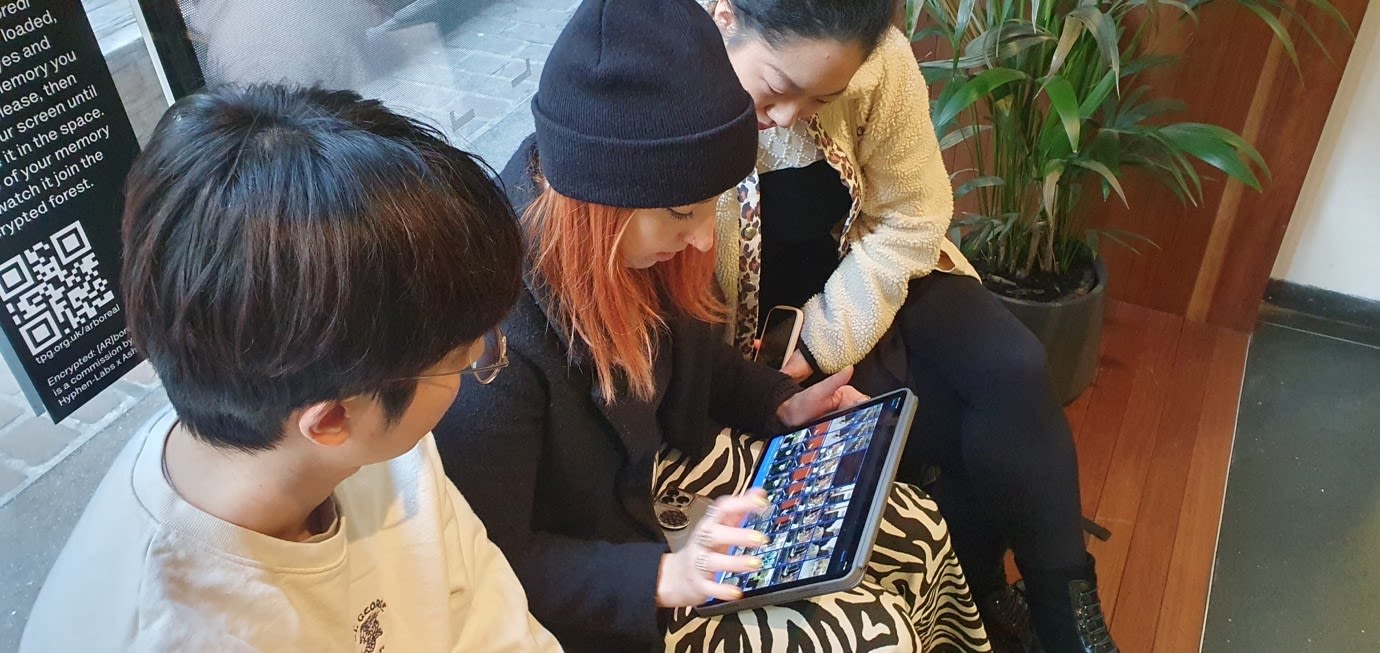 3 students looking at an ipad