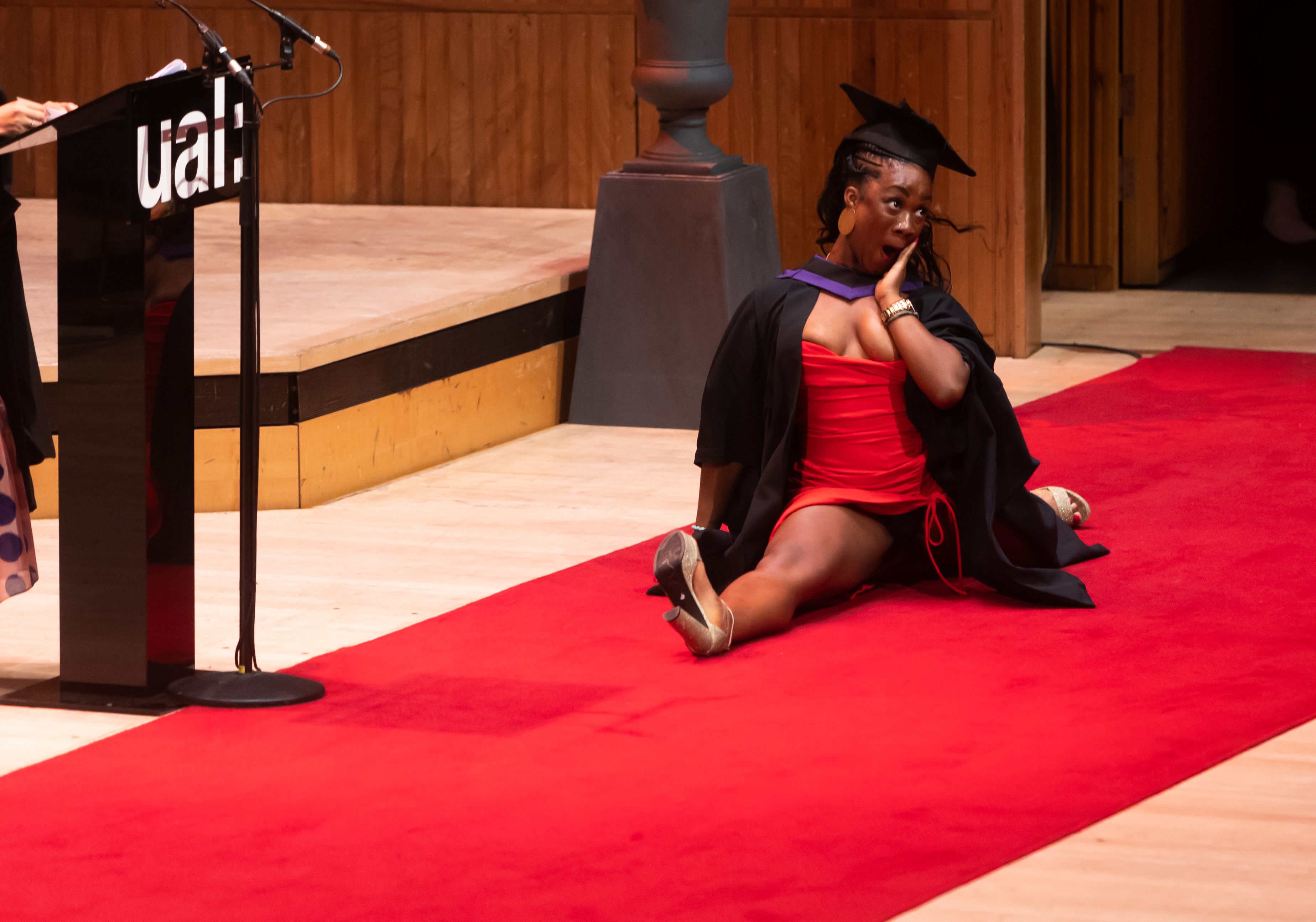 A person doing the splits on stage at graduation