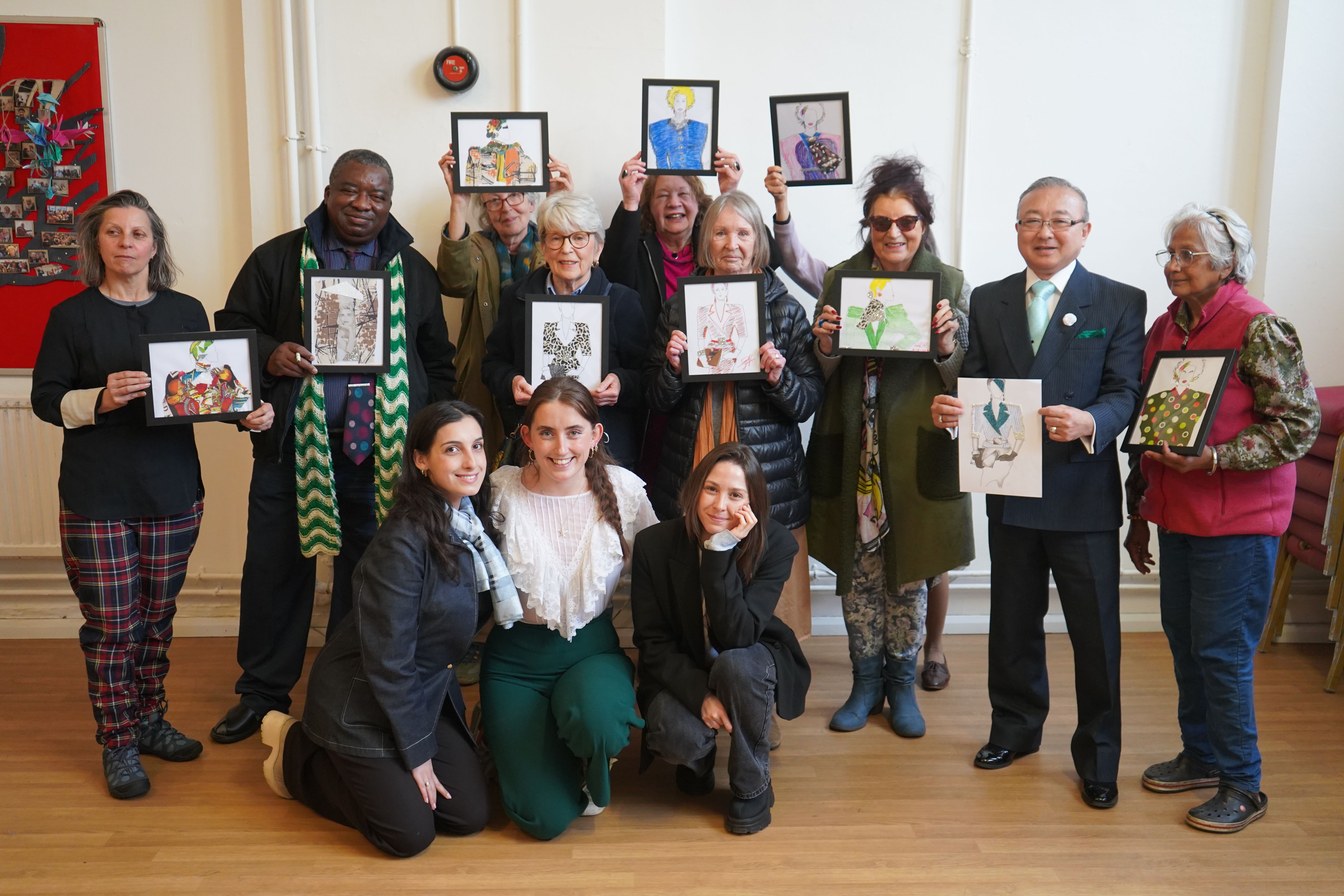 Group of people holding up artistic pieces