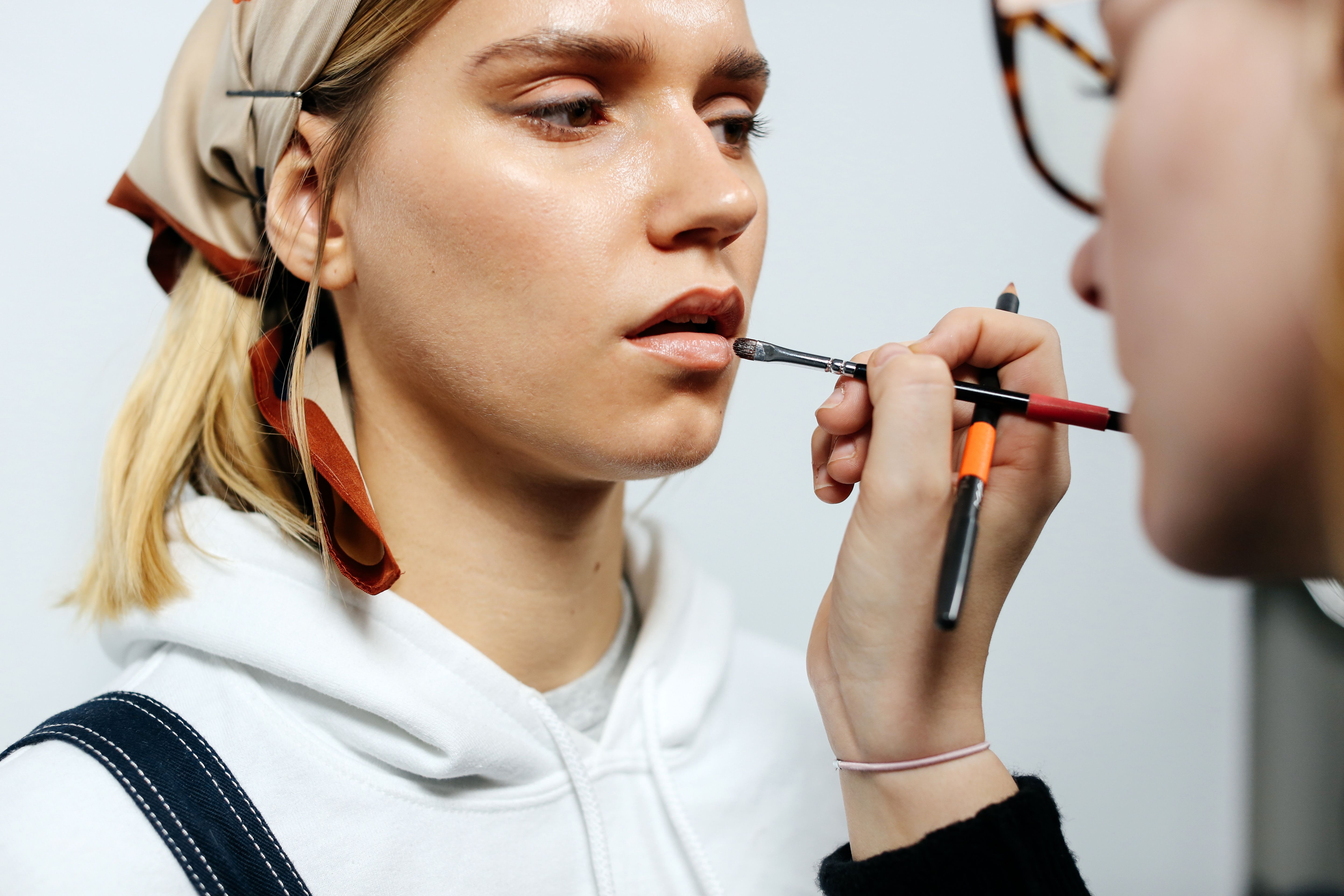 Woman putting make-up on a model