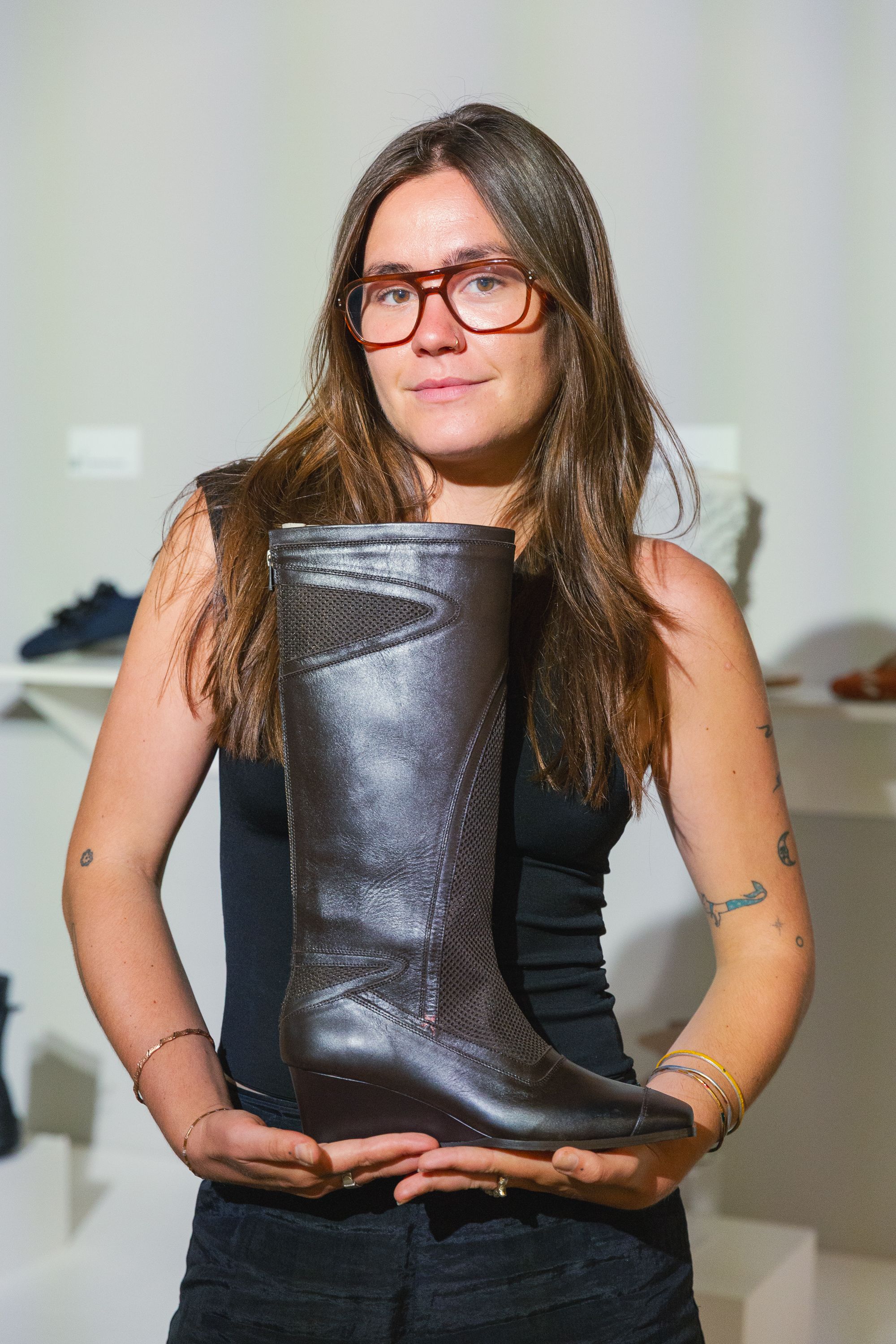 Person holding a boot and smiling at camera.