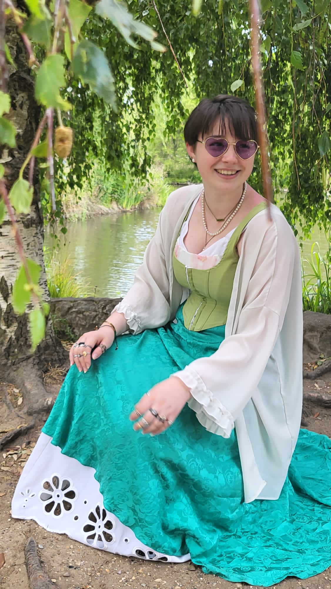 Aniena sat by a river in a long skirt