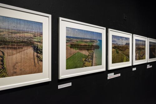 A series of framed photographs of a beach landscape.