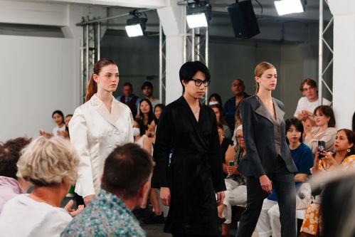 Models walking on catwalk with student