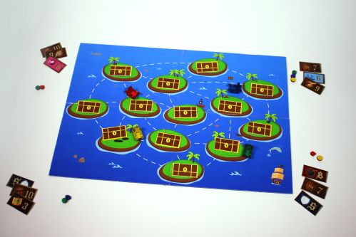 image of board game with treasure map printed on it. The game is on a table with playing cards on each corner