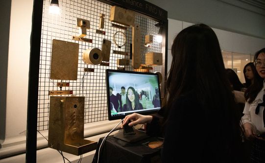 A visitor uses a front-facing camera to participate in a student project.