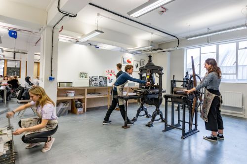 Students using a printing press  inside Central Saint Martins' Archway campus